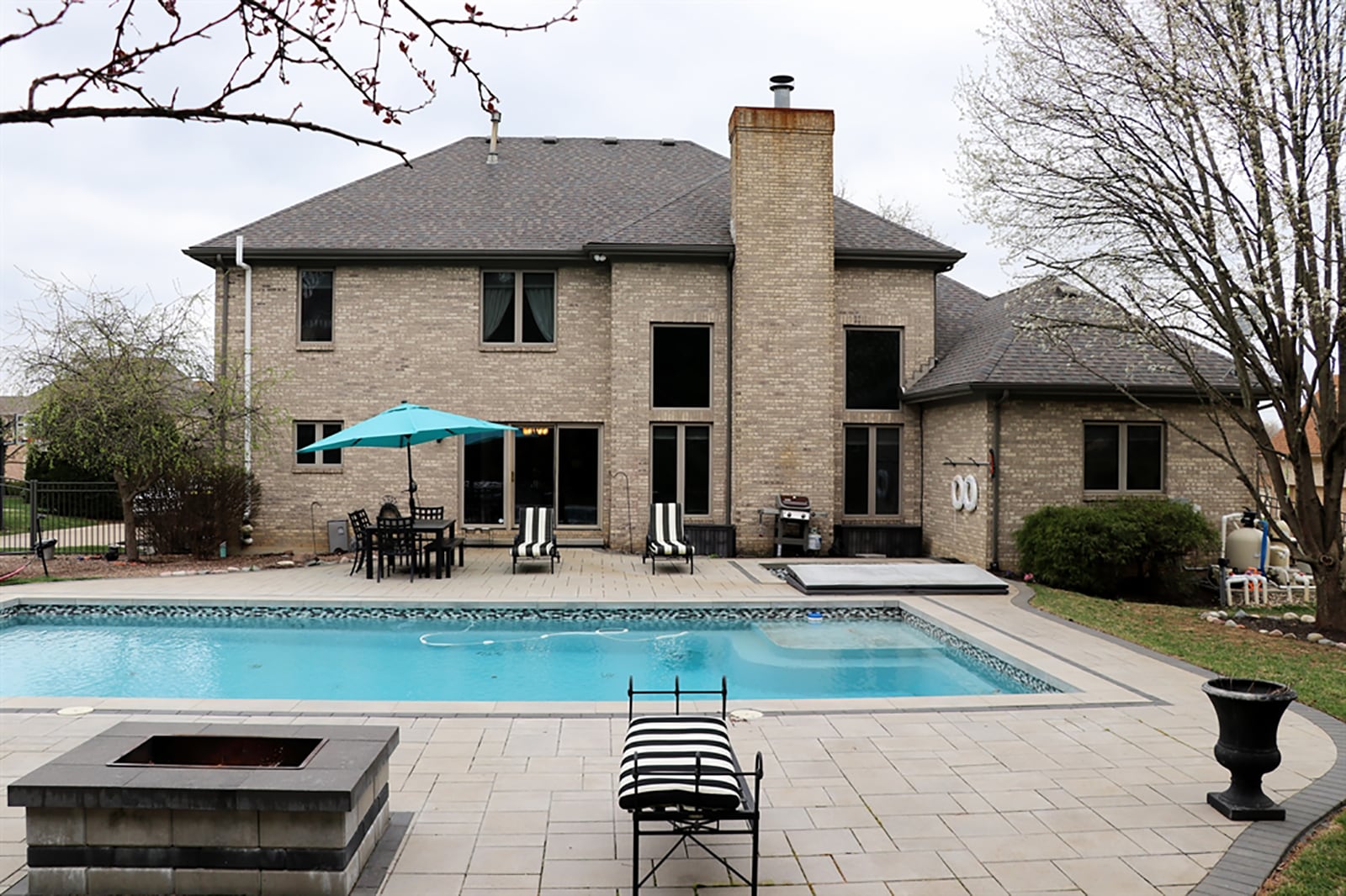 A concrete brick patio wraps around the in-ground hot tub and swimming pool in back plus offers sun deck space and a shaded fire pit area. The swimming pool is heated salt water. CONTRIBUTED PHOTO BY KATHY TYLER