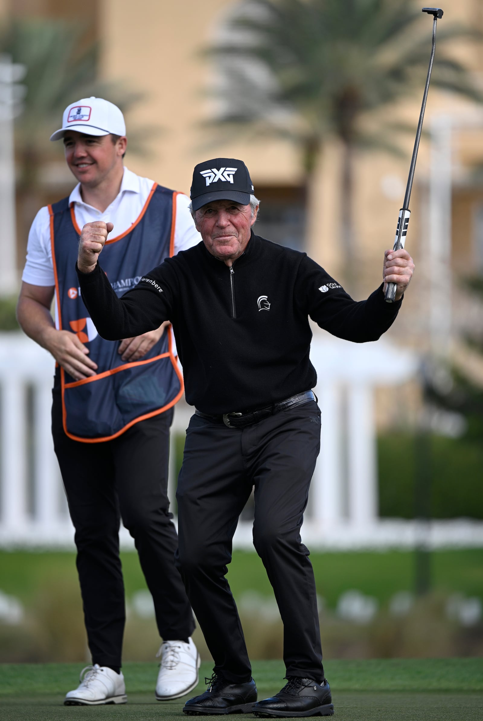 Gary Player, right, celebrates after making a putt on the 18th green as his son Wayne Player, left, looks on during the final round of the PNC Championship golf tournament, Sunday, Dec. 22, 2024, in Orlando, Fla. (AP Photo/Phelan M. Ebenhack)