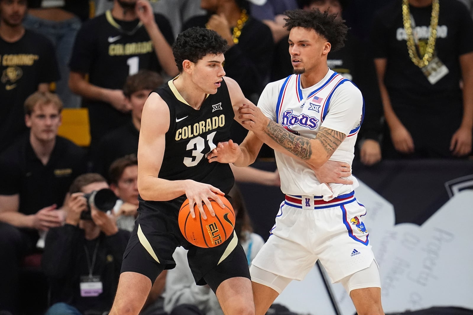 Colorado guard Harrison Carrington, left, drives to the basket as Kansas guard Zeke Mayo, right, defends in the first half of an NCAA college basketball game Monday, Feb. 24, 2025, in Boulder, Colo. (AP Photo/David Zalubowski)