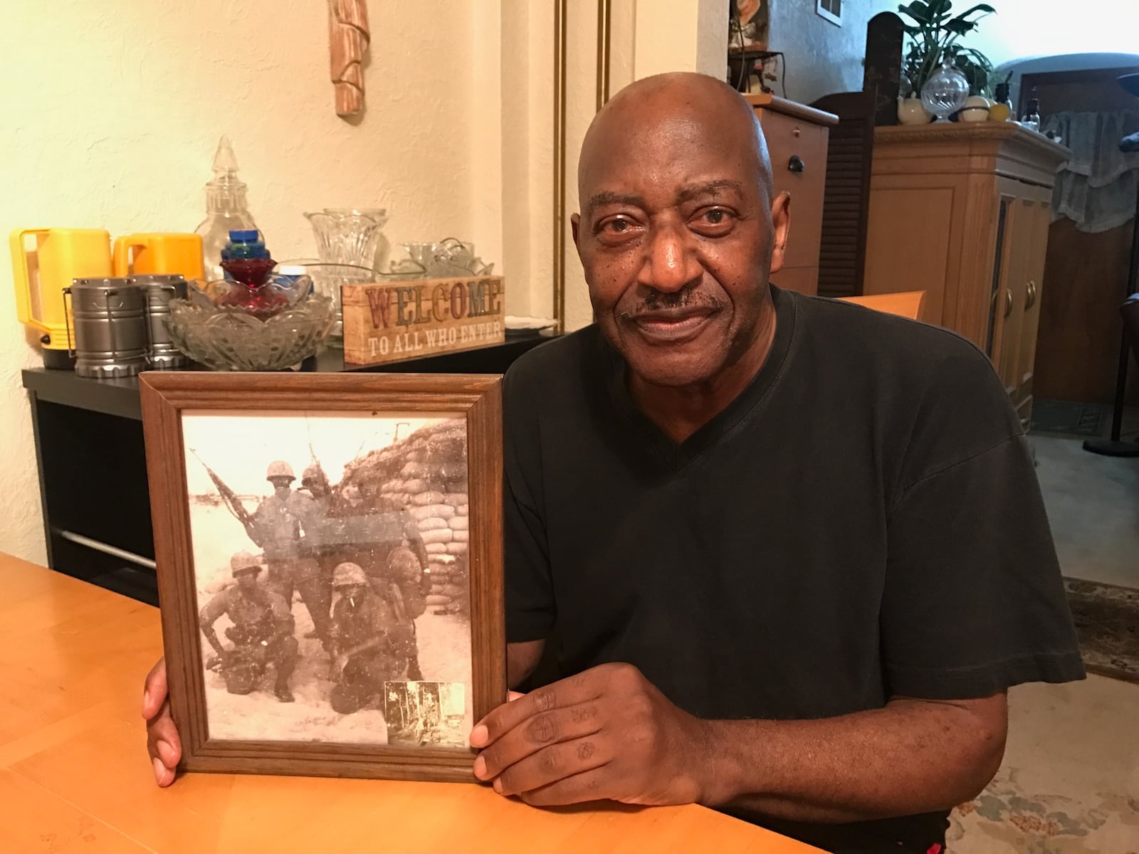 Ron Daniels shows  a photo of himself and four of his fellow U.S. soldiers at Utah Beach in Vietnam before an assault by the North Vietnamese Army in 1968. Tom Archdeacon/CONTRIBUTED