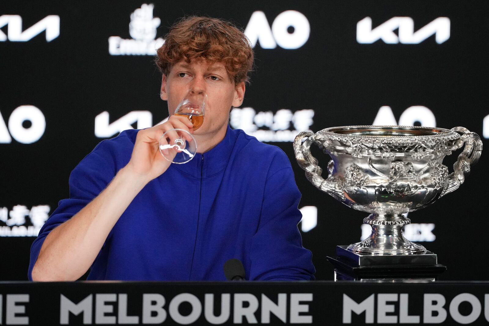 Jannik Sinner of Italy drinks a glass champagne during a press conference after defeating Alexander Zverev of Germany in the men's singles final at the Australian Open tennis championship in Melbourne, Australia, Monday, Jan. 27, 2025. (AP Photo/Manish Swarup)