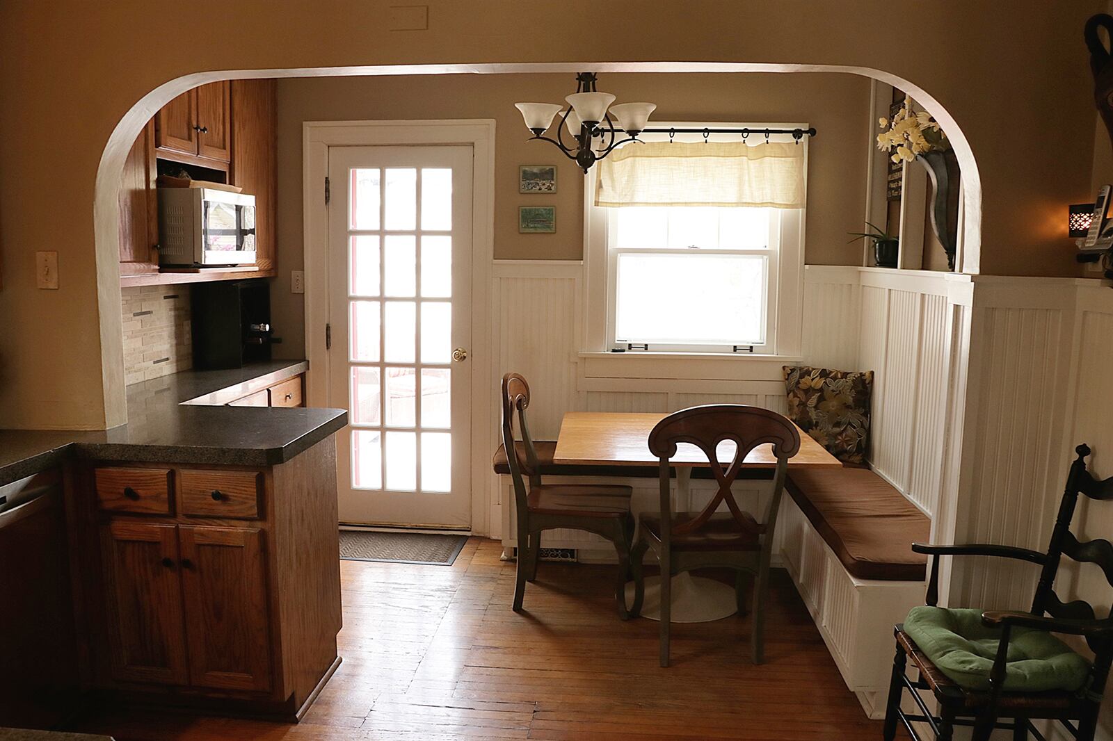 Wainscoting and display nooks accent the breakfast area, which has an L-shaped, built-in bench seat. A window is above part of the bench seating, which also has built-in storage. CONTRIBUTED PHOTO BY KATHY TYLER