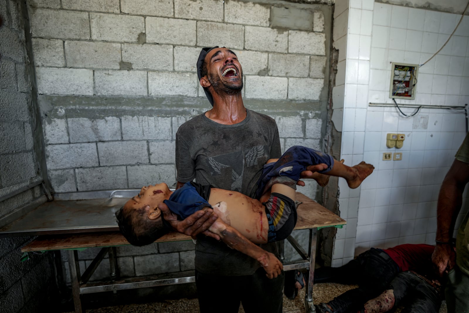 FILE - A Palestinian man mourns a relative killed in the Israeli bombardment of the Gaza Strip at a hospital morgue in Deir al-Balah, Wednesday, Aug. 28, 2024. (AP Photo/Abdel Kareem Hana, File)