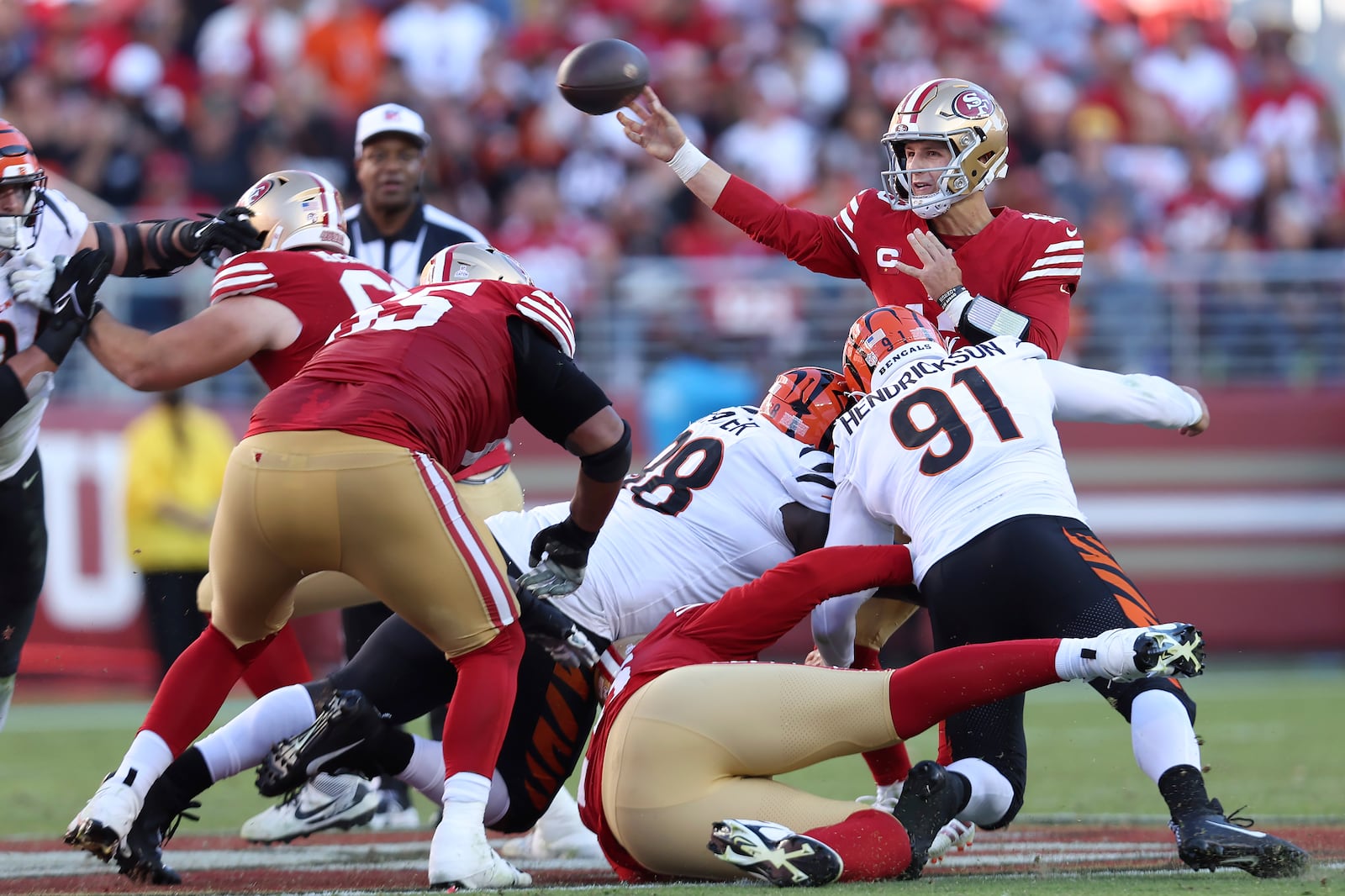 San Francisco 49ers quarterback Brock Purdy, top, passes as Cincinnati Bengals defensive end Trey Hendrickson (91) and defensive tackle DJ Reader apply pressure during the second half of an NFL football game in Santa Clara, Calif., Sunday, Oct. 29, 2023. (AP Photo/Jed Jacobsohn)