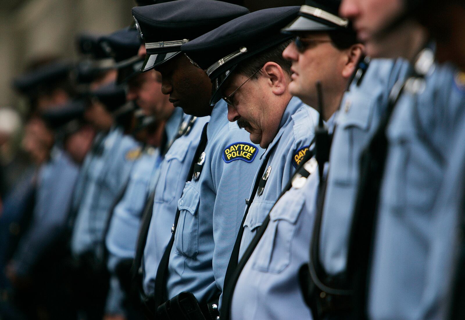 Dayton Police officers lower their head during the Montgomery County Law Enforcement Memorial ceremony held on Courthouse Square in downtown Dayton. Jim Noelker/Dayton Daily News