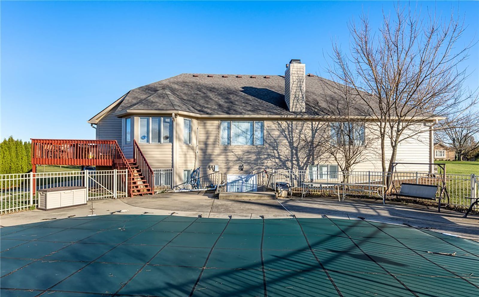 The rear of the home has a fully fenced inground pool and raised wood deck.