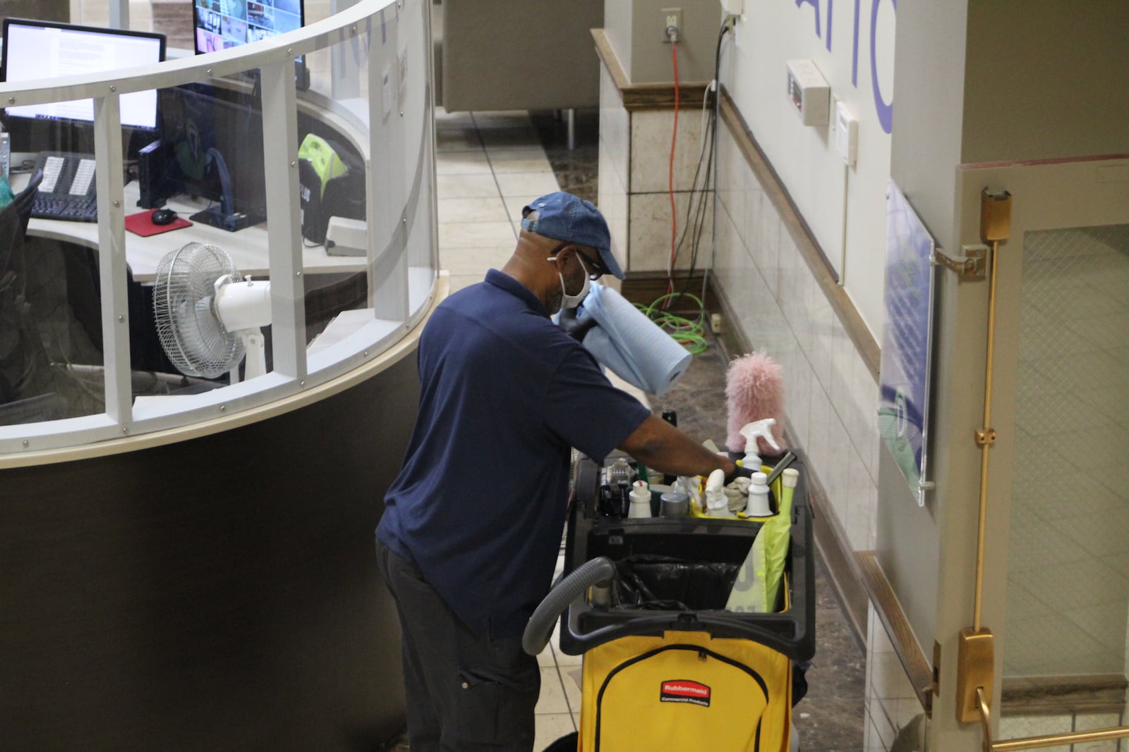 A sanitation worker cleans the front desk area of City Hall. CORNELIUS FROLIK / STAFF