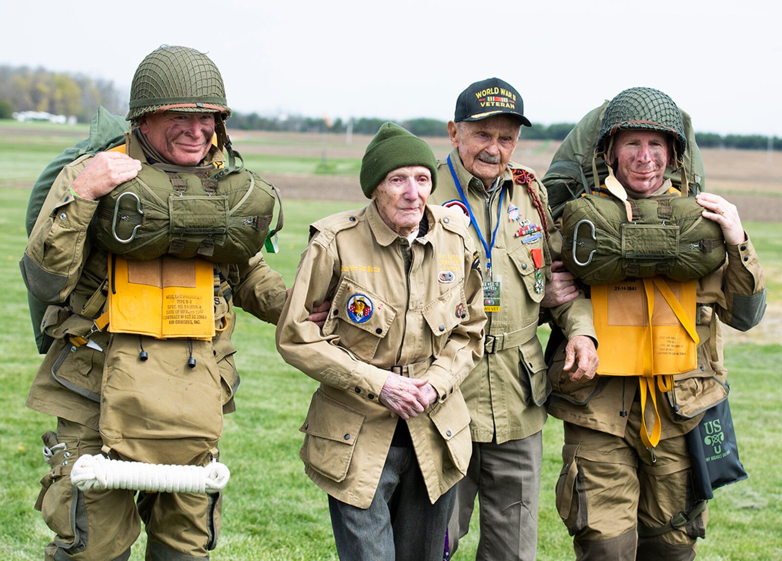 World War II airborne demonstration team members walk with WWII veterans Dan McBride, (center left) and Jim “Pee Wee” Martin (center right) as they exit the drop zone during a 100th birthday celebration held in Martin’s honor April 23 in Xenia, Ohio. Both McBride and Martin, served as paratroopers assigned to 101st Airborne Division out of Fort Campbell, Kentucky. U.S. AIR FORCE PHOTO/WESLEY FARNSWORTH