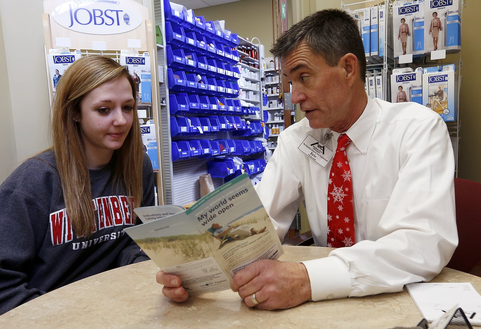 In this 2016 file photo, Eric Juergens of Madison Avenue Pharmacy talks with Erin Bass in the pharmacy’s consultation room. BILL LACKEY/STAFF