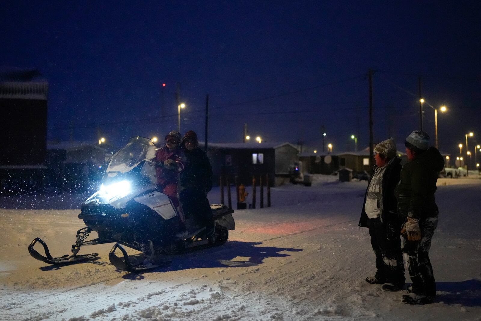 Children stop to talk with friends on a snowmobile as they play in the snow after school in the village of Kaktovik, Alaska, Wednesday, Oct. 16, 2024. (AP Photo/Lindsey Wasson)