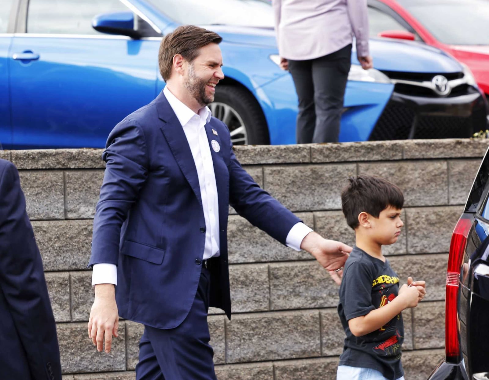 Vice president candidate JD Vance, a U.S. Senator from Middletown, leads one of his children to the vehicle after voting with his wife and kids in Cincinnati. NICK GRAHAM/STAFF