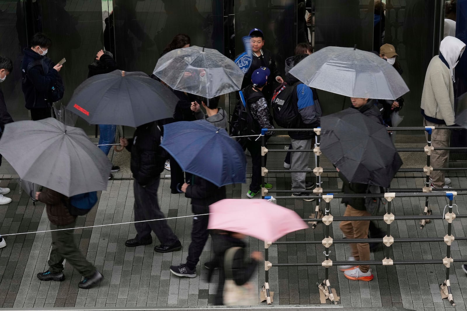 Baseball fans wait in line to get into an MLB souvenir store before the Tokyo Series exhibition games with the Los Angeles Dodgers, the Chicago Cubs, the Yomiuri Giants and the Hanshin Tigers at Tokyo Dome in Tokyo, Sunday, March 16, 2025. (AP Photo/Hiro Komae)