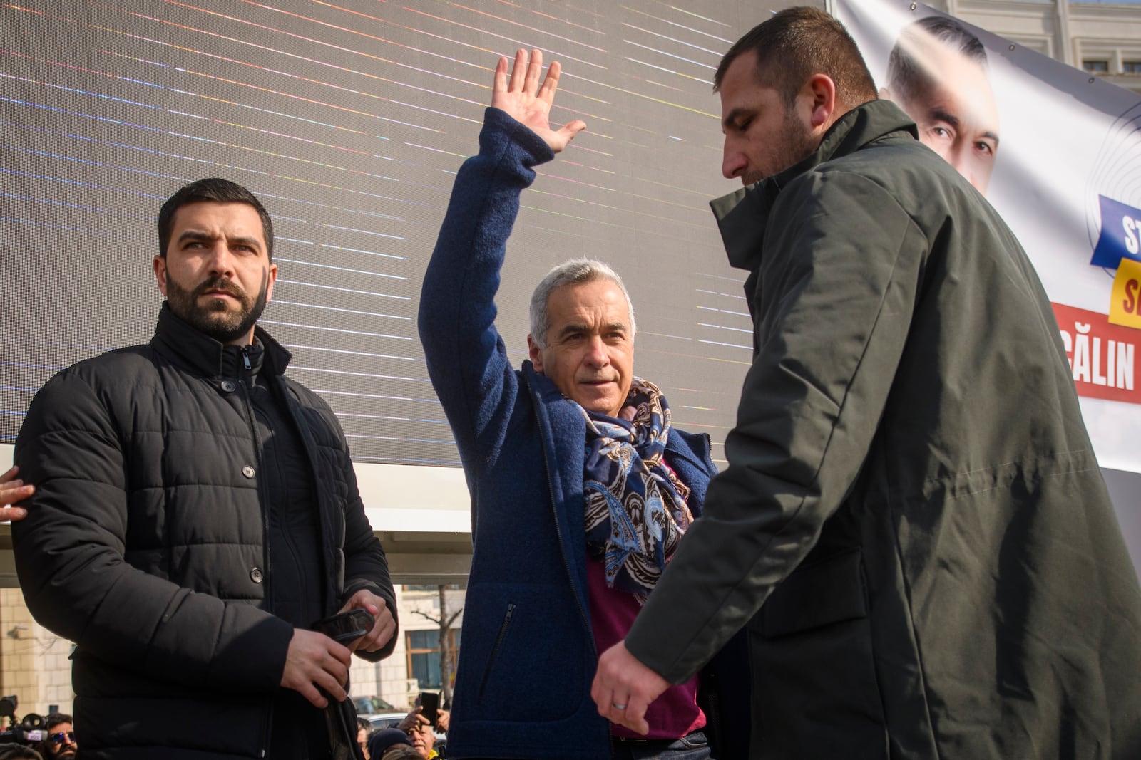 Calin Georgescu, the winner of Romania's first round of presidential election, annulled by the Constitutional Court, waves to supporters gathered for a protest outside the Romanian parliament in Bucharest, Romania, Saturday, Feb. 22, 2025. (AP Photo/Alexandru Dobre)