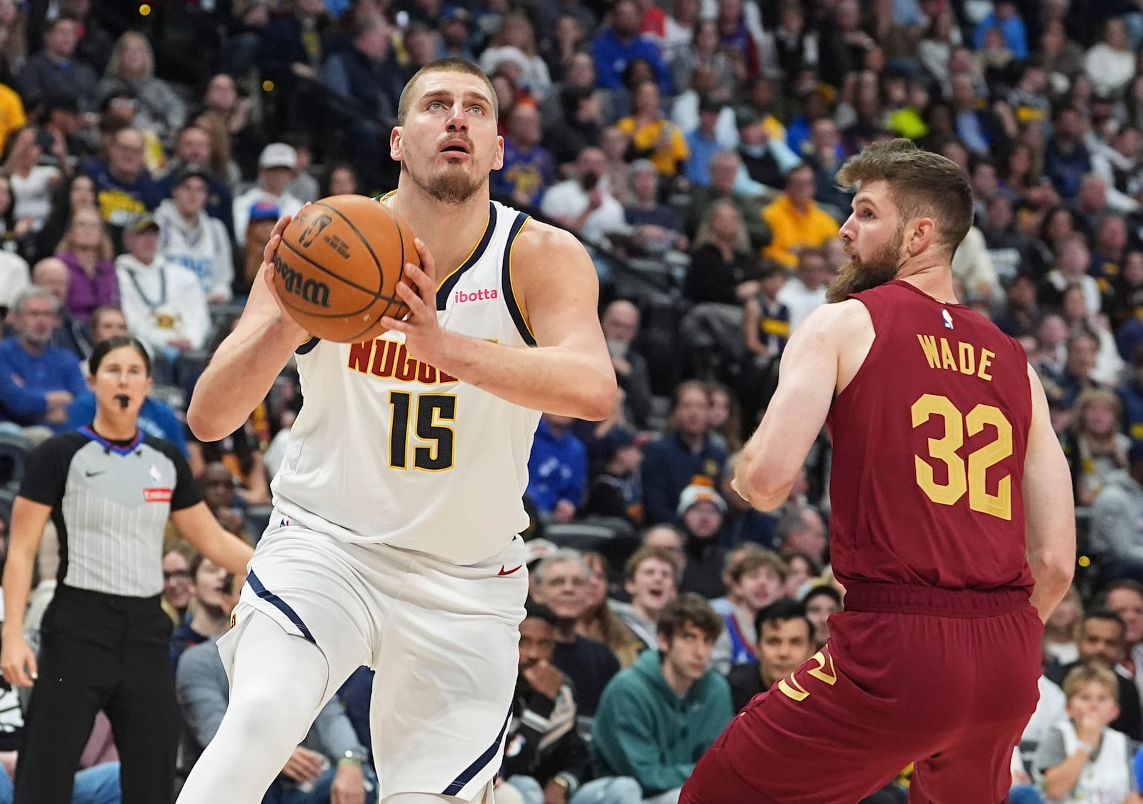 Denver Nuggets center Nikola Jokic, left, drives to the basket past Cleveland Cavaliers forward Dean Wade in the first half of an NBA basketball game Friday, Dec. 27, 2024, in Denver. (AP Photo/David Zalubowski)