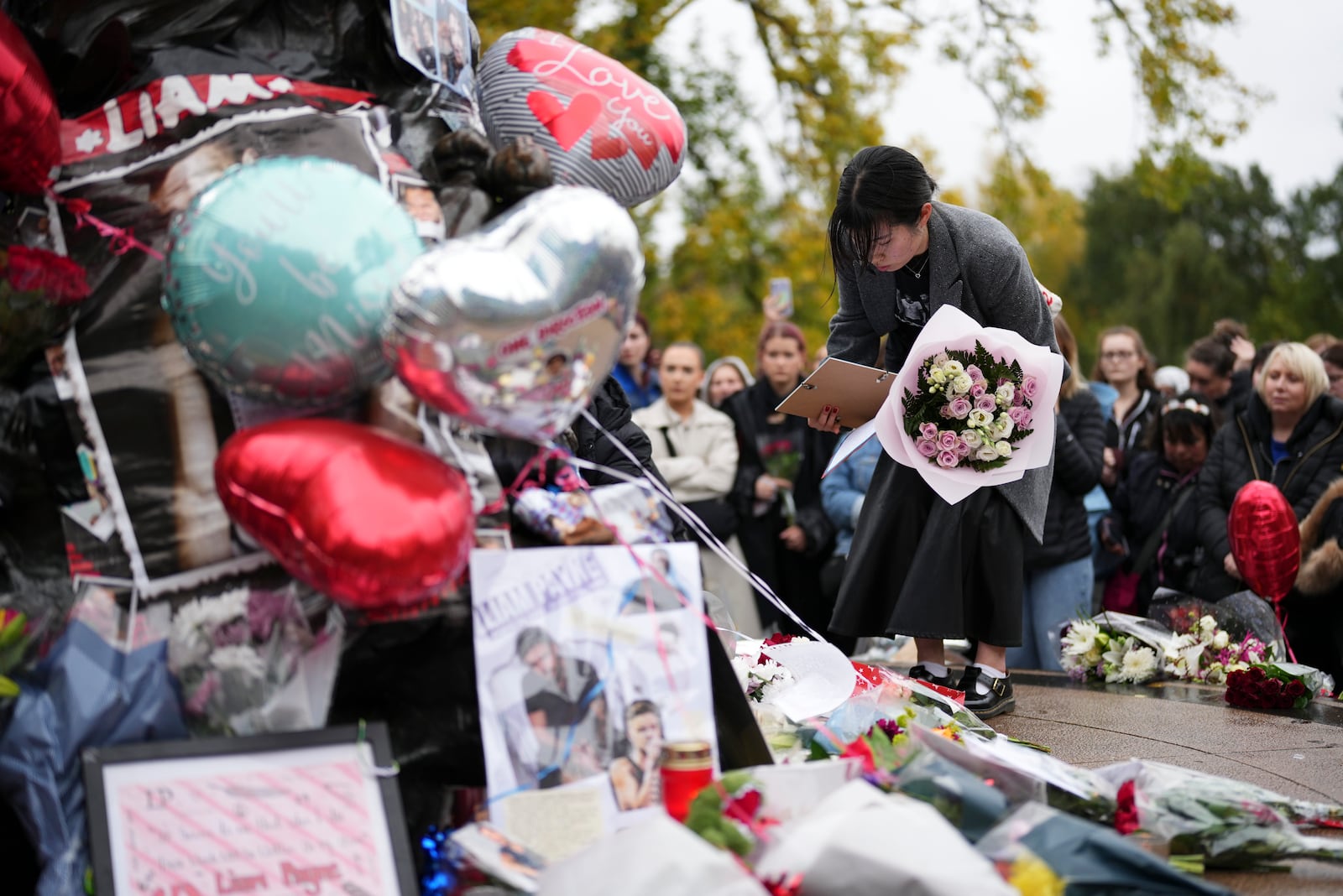 Fans gather to pay tribute to late British singer Liam Payne, former member of the British pop band One Direction in Hyde Park in London, Sunday, Oct. 20, 2024, in London. (Photo by Scott A Garfitt/Invision/AP)