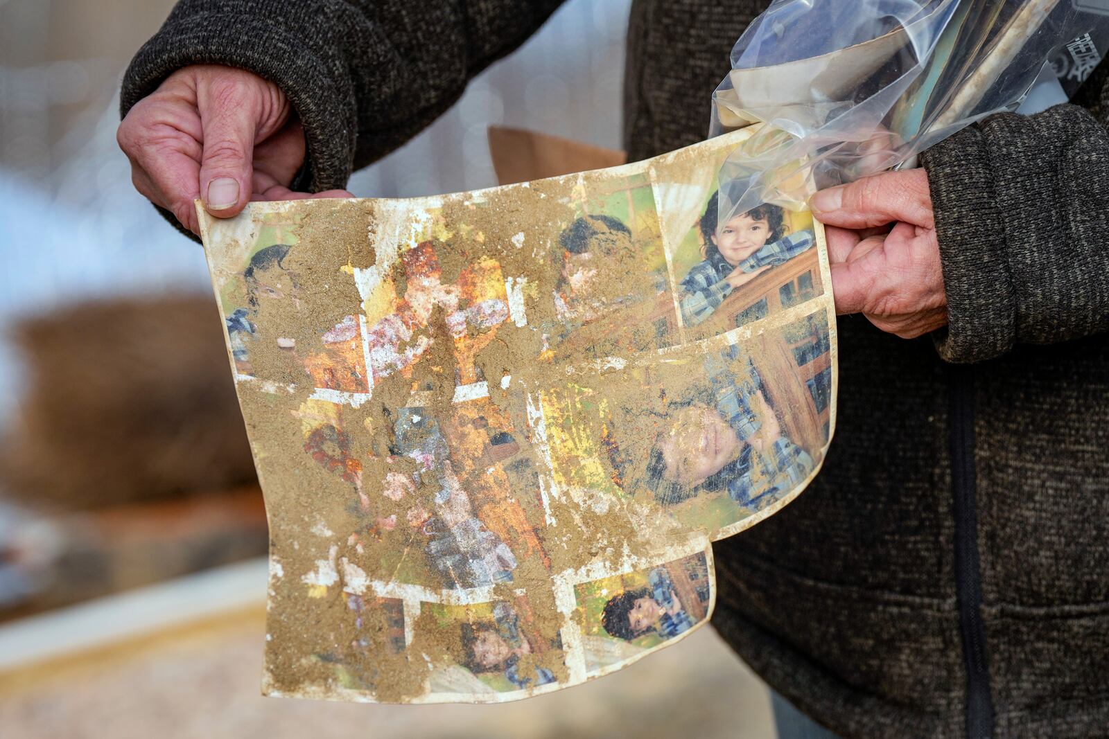 Vickie Revis holds one of several mud-stained family photographs that were recovered after her home was destroyed by Hurricane Helene, Wednesday, Feb. 5, 2025, in Swannanoa, N.C. (AP Photo/Kathy Kmonicek)