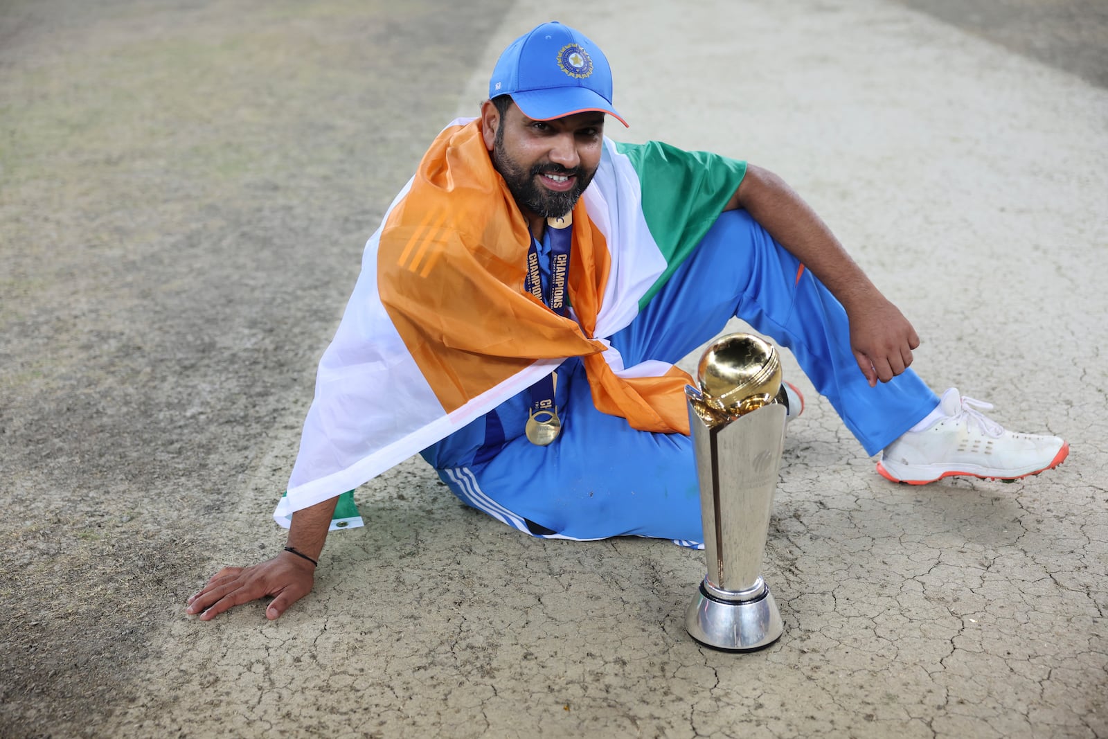 India's captain Rohit Sharma poses with the winners trophy after defeating New Zealand in the final cricket match of the ICC Champions Trophy at Dubai International Cricket Stadium in Dubai, United Arab Emirates, Sunday, March 9, 2025. (AP Photo/Christopher Pike)