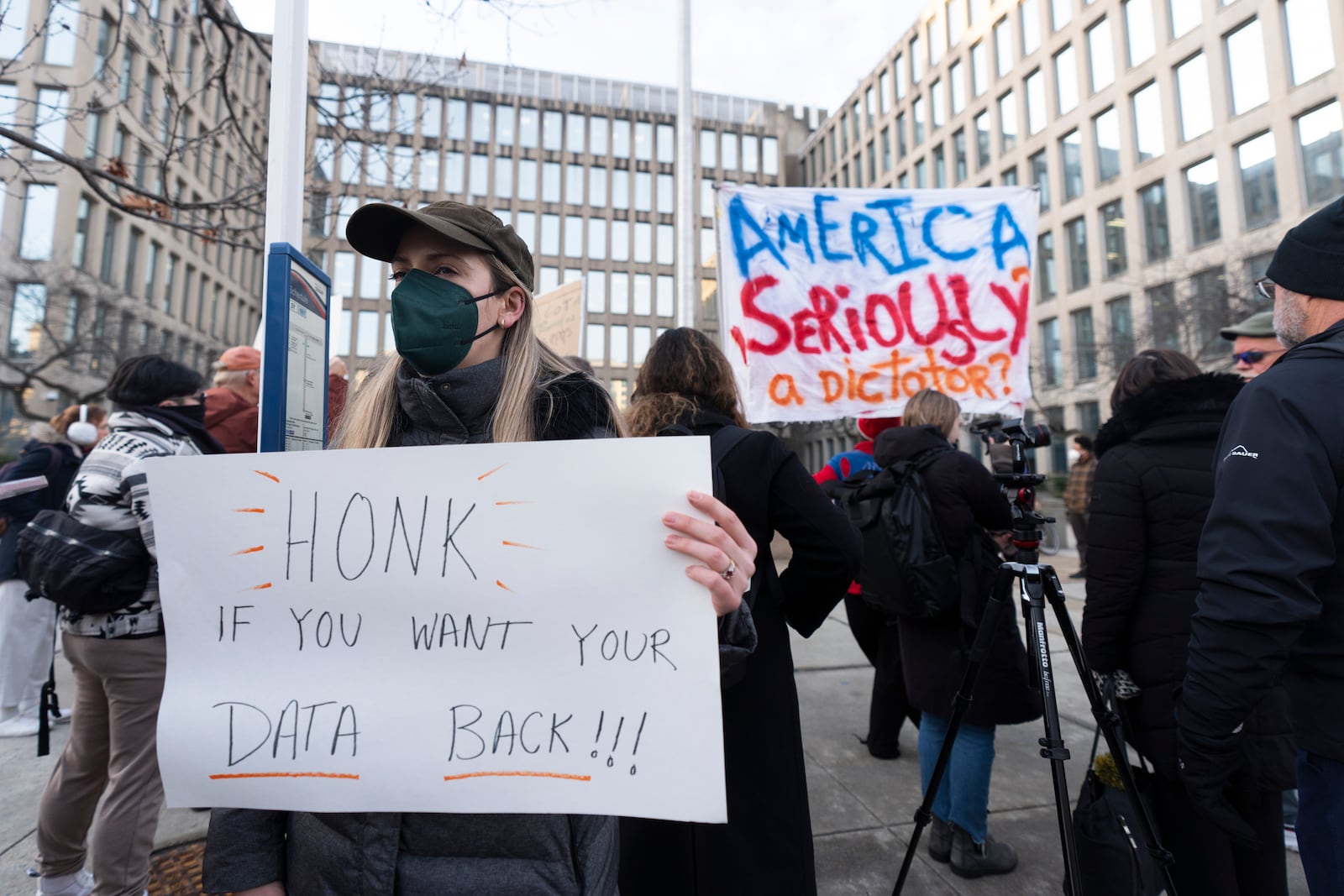 Protesters hold banners during a rally in front of the Office of Personnel Management, Monday, Feb. 3, 2025, in Washington. President Donald Trump is relying on a relatively obscure federal agency to reshape government. The Office of Personnel Management was created in 1979 by President Jimmy Carter and is the equivalent of the government's human resources department. It helps manage the civil service, including pay schedules, health insurance and pension programs. The agency has offered millions of federal workers eight months of salary if they voluntarily choose to leave their jobs by Feb. 6. (AP Photo/Manuel Balce Ceneta)