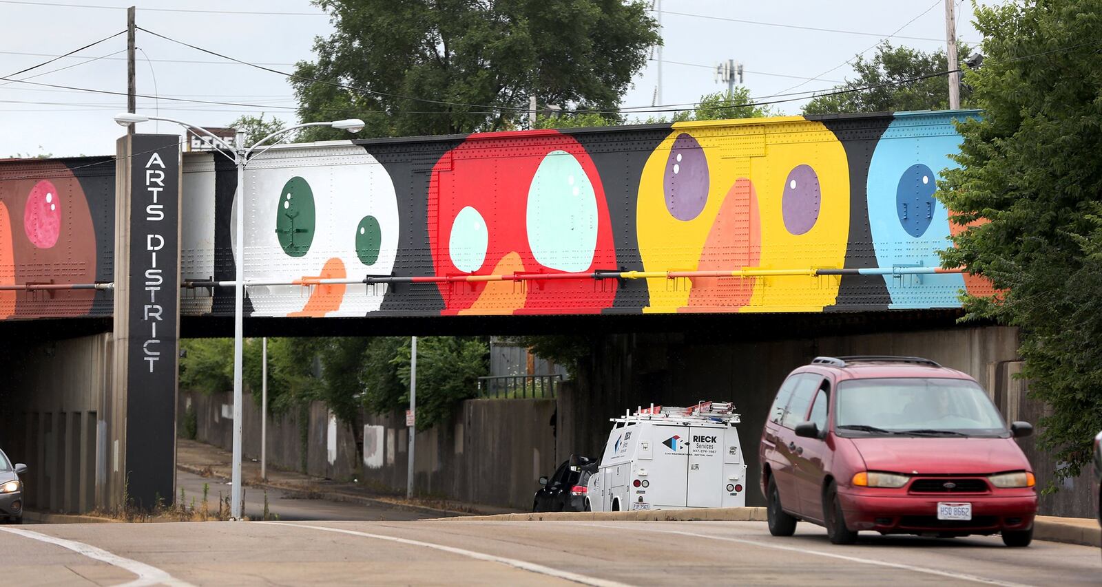 A whimsical mural of birds decorates the train overpass near the intersection of Keowee and First streets. LISA POWELL / STAFF