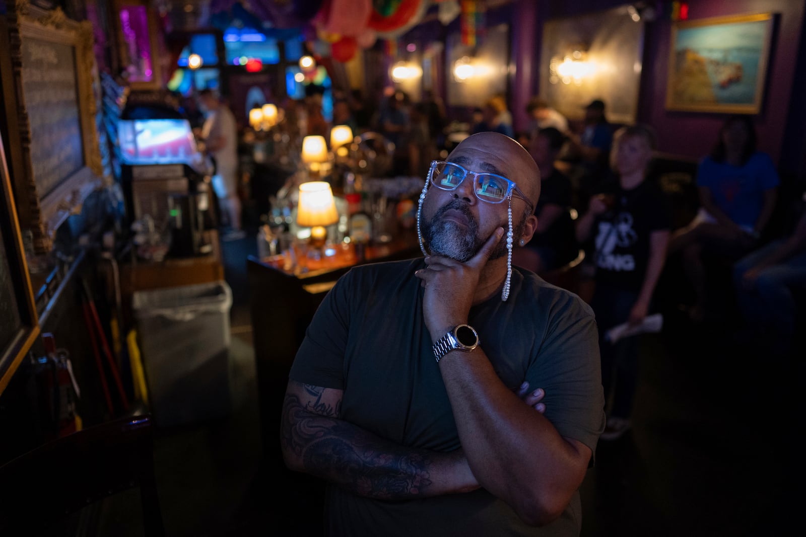 Jocardo Ralston, 47, from Pennsylvania, looks up to a television to watch the presidential debate between President Joe Biden and Republican presidential candidate former President Donald Trump at Tillie's Lounge on Thursday, June 27, 2024, in Cincinnati. (AP Photo/Carolyn Kaster)