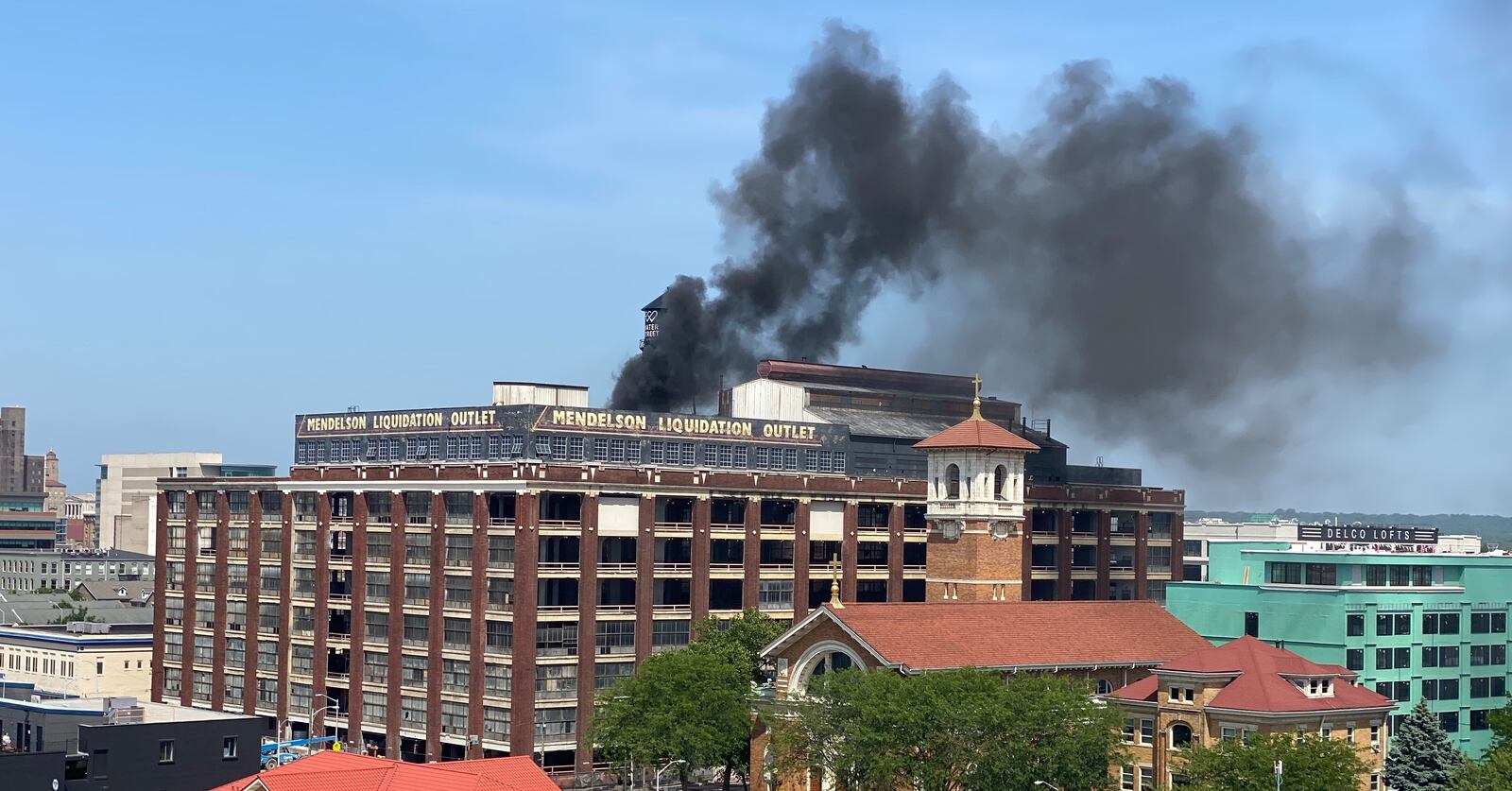 Heavy black smoke was coming from the roof of the former Mendelsons building in downtown Dayton. BEN MCLAUGHLIN/STAFF