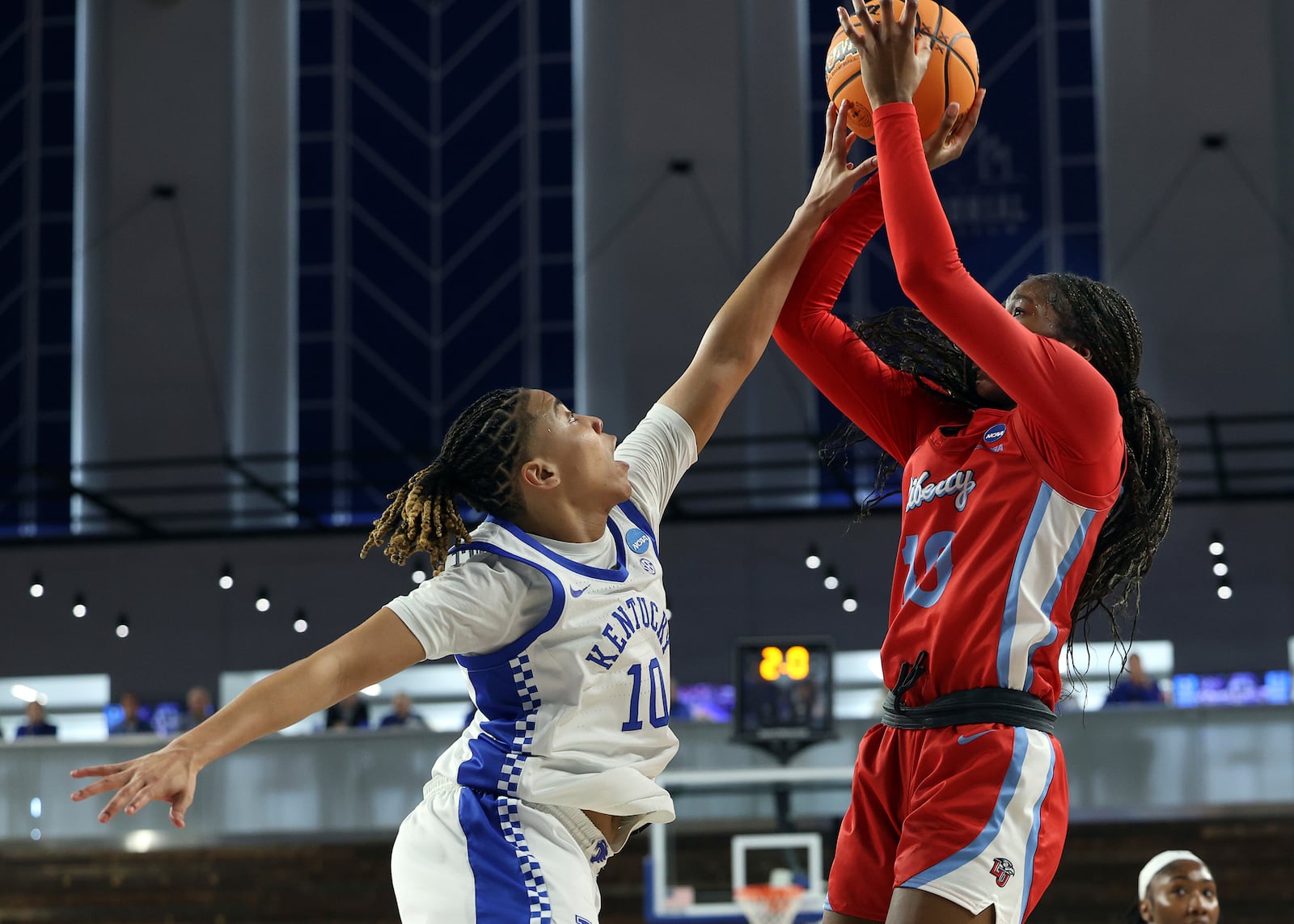 Liberty's Brooke Moore, right, shoots while pressured by Kentucky's Dazia Lawrence in the first round of the NCAA college basketball tournament in Lexington, Ky., Friday, March 21, 2025. (AP Photo/James Crisp)