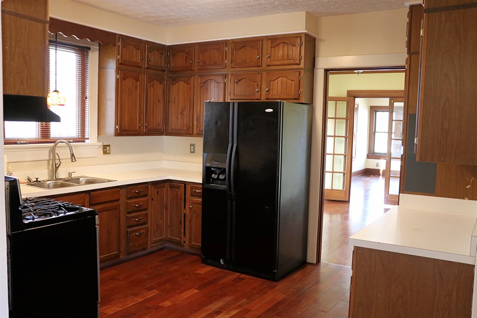 The kitchen is at the center of the house. There is a window above the double sink, and the counters wrap around to the range and the refrigerator. 