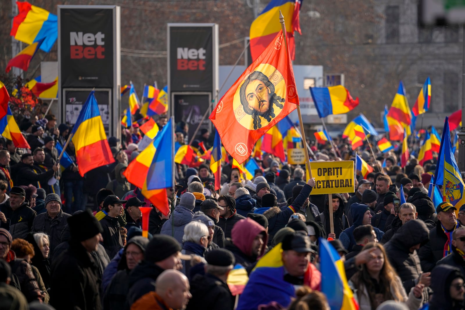 Protesters wave a flag depicting Jesus Christ during a rally organized by the right wing Alliance for the Unity of Romanians (AUR), calling for free elections after Romania' s Constitutional Court annulled the first round of presidential elections last December, in Bucharest, Romania, Sunday, Jan. 12, 2025. (AP Photo/Vadim Ghirda)