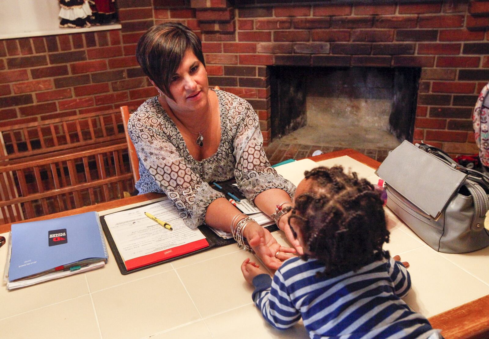 Montgomery County Children Services caseworker Janine Elders visits a child in custody currently receiving foster care from Patricia Boring. Elders, with Children Services 22 years, now works with foster parents but spent her first years on the job working directly with families in crisis. She said she was able to cope that long by not taking work home with her. CHRIS STEWART / STAFF