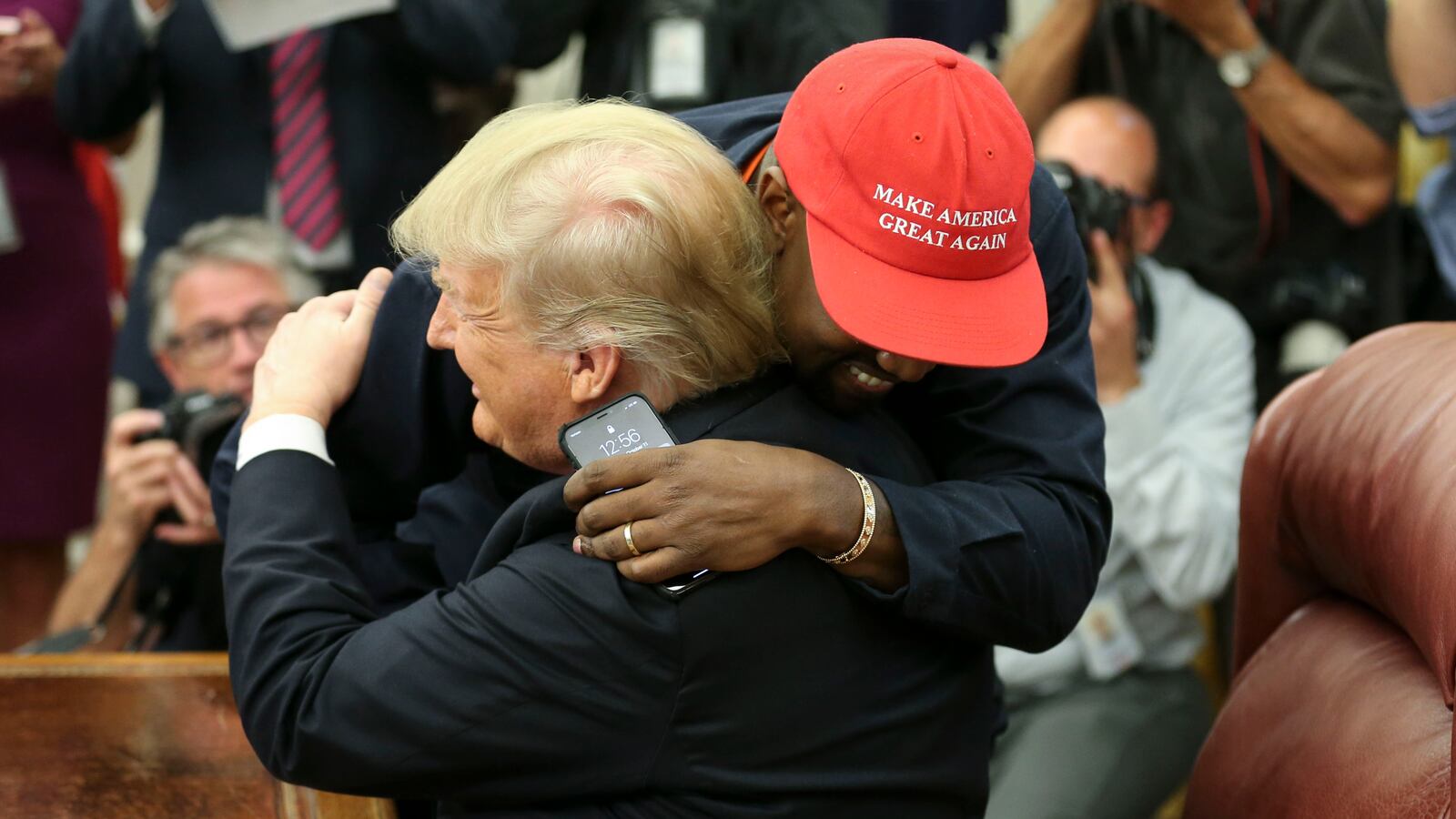 U.S. President Donald Trump hugs rapper Kanye West during a meeting in the Oval office of the White House on October 11, 2018, in Washington, D.C.