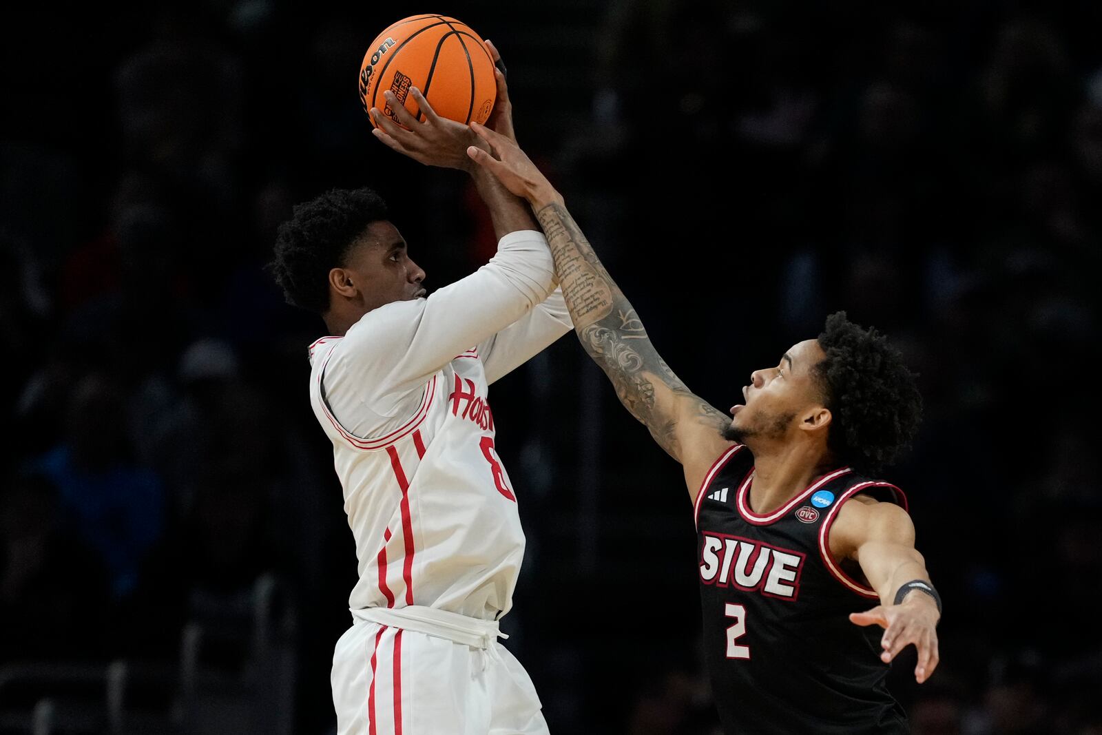 SIU Edwardsville guard Desmond Polk (2) tries to block a shot by Houston guard Mylik Wilson (8) during the second half in the first round of the NCAA college basketball tournament, Thursday, March 20, 2025, in Wichita, Kan. (AP Photo/Charlie Riedel)