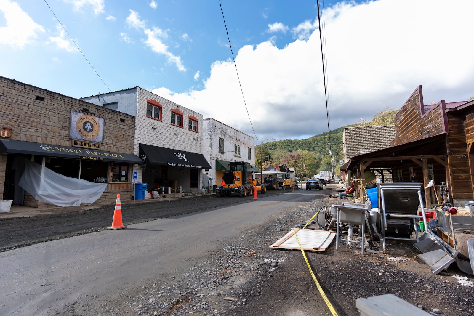 Damaged businesses are seen as Bridge Street in Hot Springs, N.C. is repaved in the aftermath of Hurricane Helene, on Oct. 16, 2024. (AP Photo/Stephanie Scarbrough)