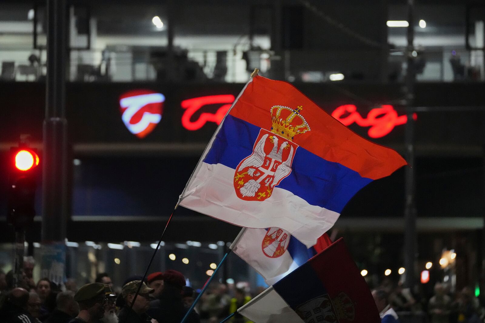 People wave flags as they wait for students to arrive ahead of a major rally this weekend in downtown Belgrade, Serbia, Friday, March 14, 2025. (AP Photo/Darko Vojinovic)