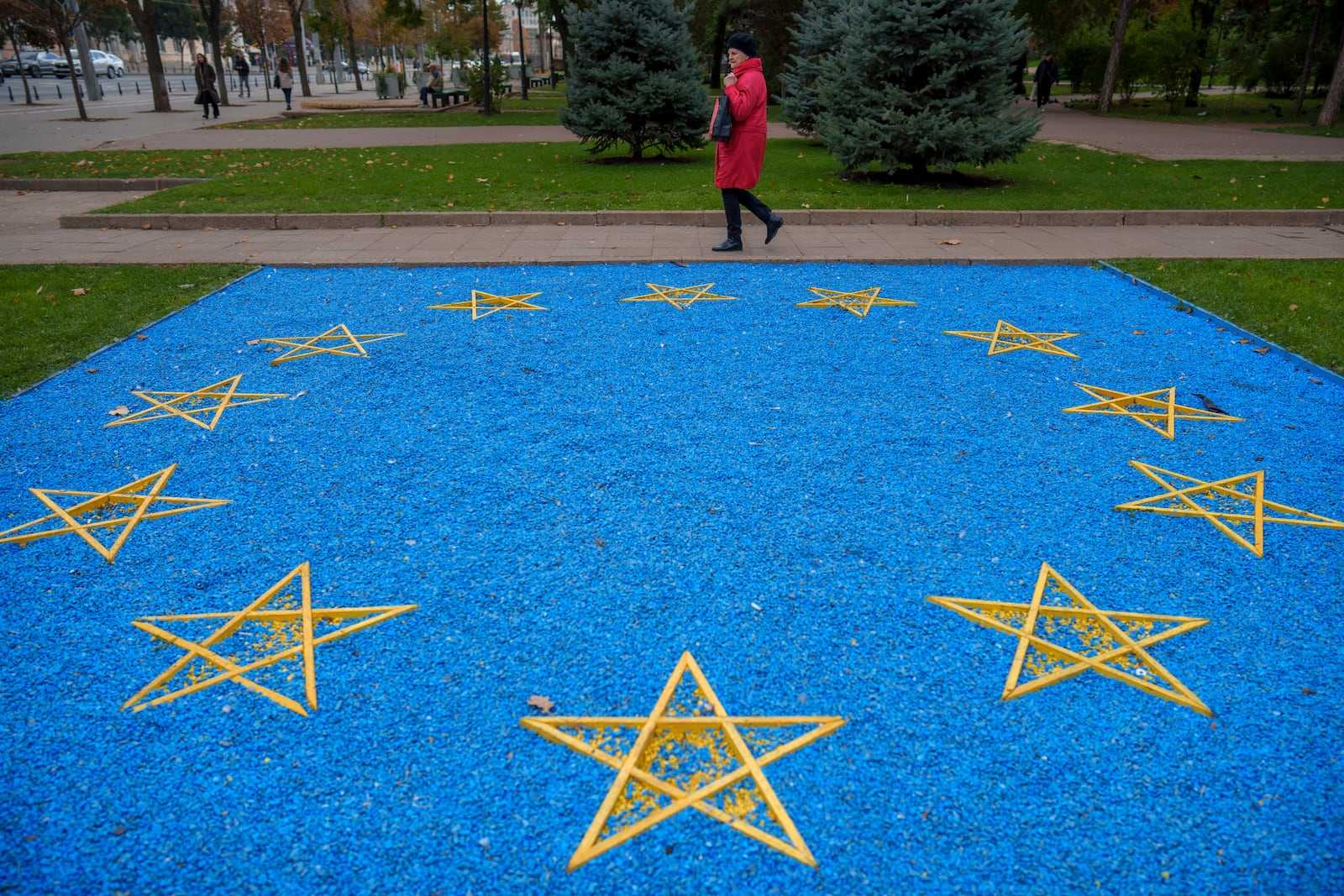 A woman walks by an European Union flag made of blue pebbles in Chisinau, Moldova, Thursday, Oct. 17, 2024, ahead of a presidential election and a referendum of whether to enshrine in Moldova's Constitution its path to European Union membership taking place on Oct.20. (AP Photo/Vadim Ghirda)