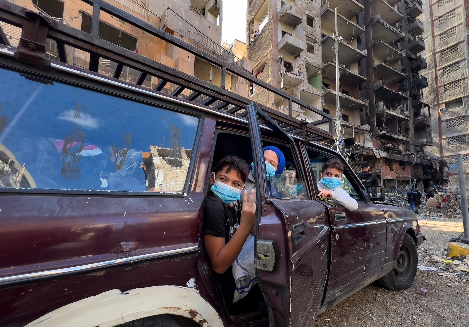 Children sit in a car as they wait their parents, who are collecting belongings from their house, which was destroyed by an Israeli airstrike in Dahiyeh, in the southern suburb of Beirut, Lebanon, Monday, Nov. 11, 2024. (AP Photo/Hussein Malla)