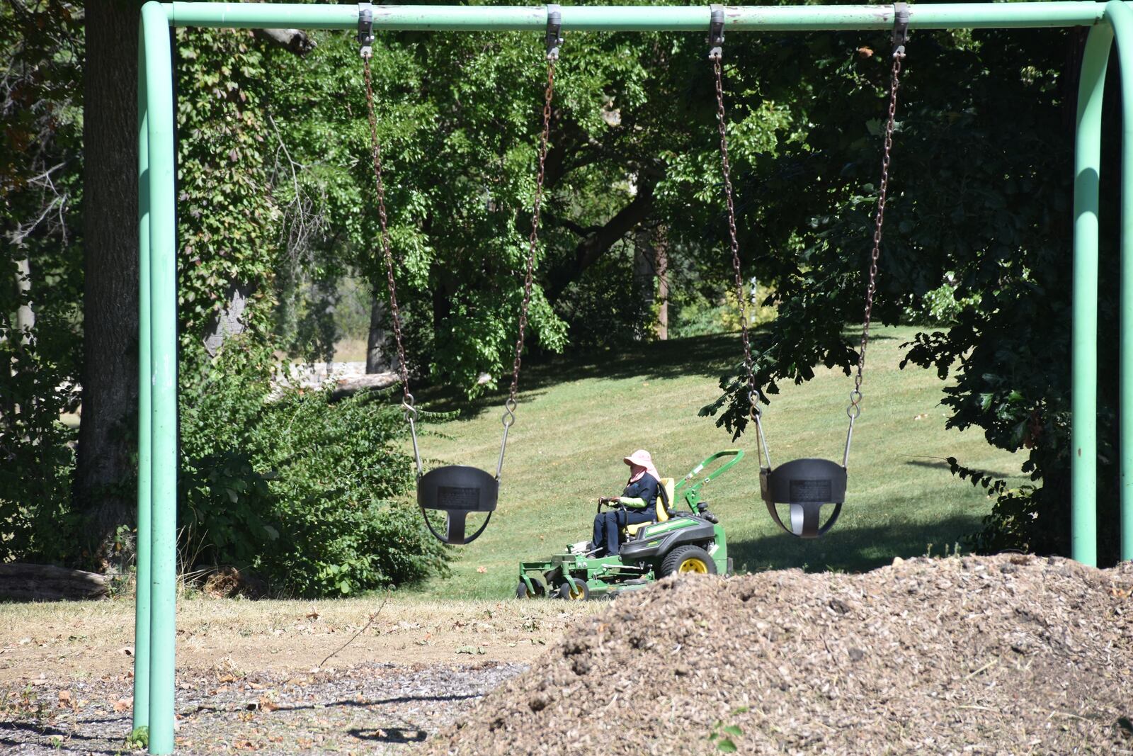 Crews on lawnmowers work on McCabe Park in West Dayton in September 2024. CORNELIUS FROLIK / STAFF