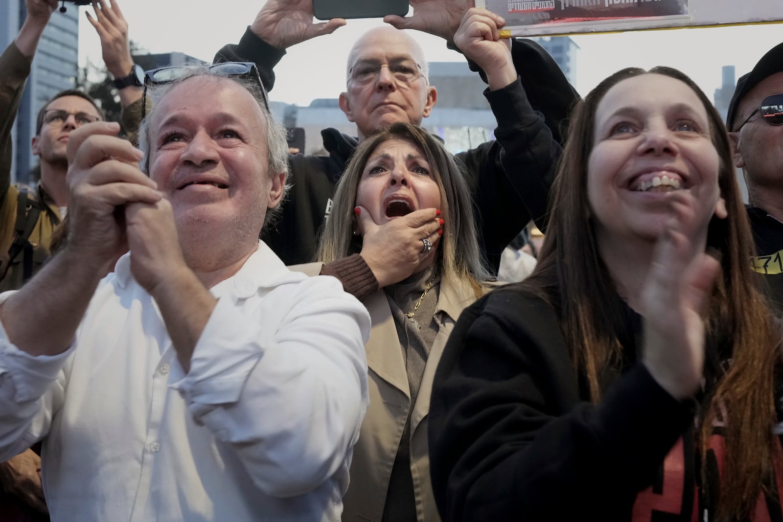 Relatives and friends of people killed and abducted by Hamas and taken into Gaza, react to the news of the hostages' release, as they gather in Tel Aviv, Israel on Sunday, Jan. 19, 2025. (AP Photo/Maya Alleruzzo)