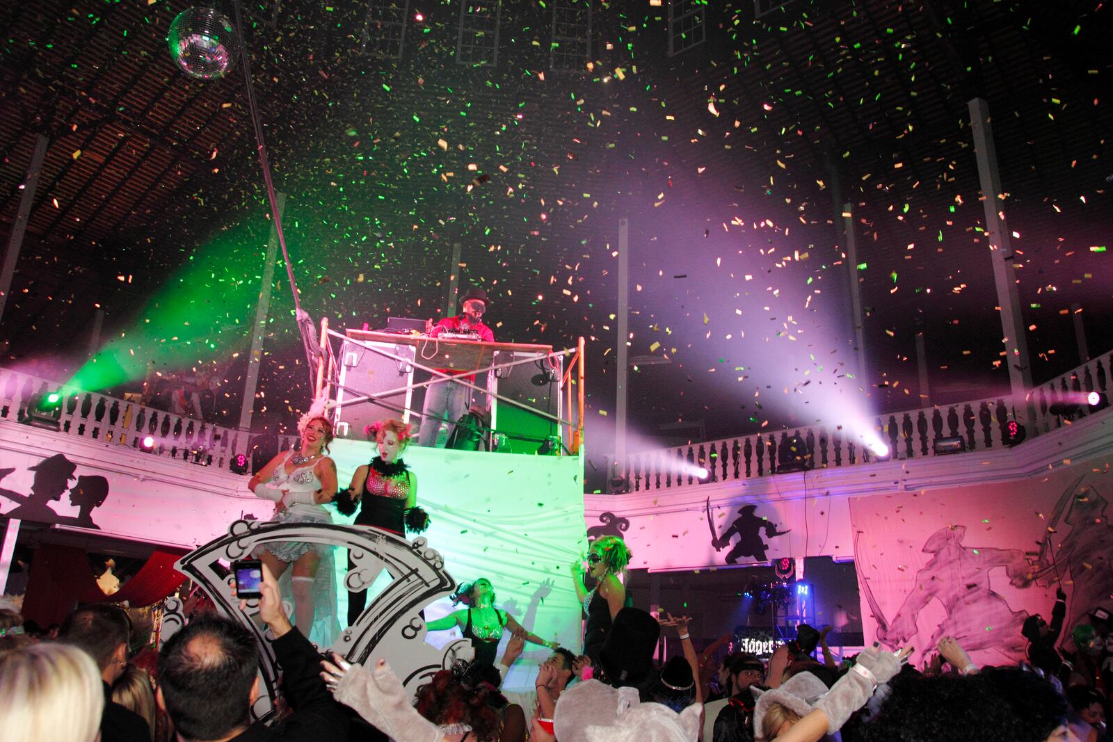 The DJ Mowgli spins tunes from the top of a raised platform, as dancers perform and a longtime tradition of confettii at midnight continues during Masquerage 2012 in the Roundhouse at the Montgomery County Fairgrounds in Dayton, Saturday, October 20, 2012.