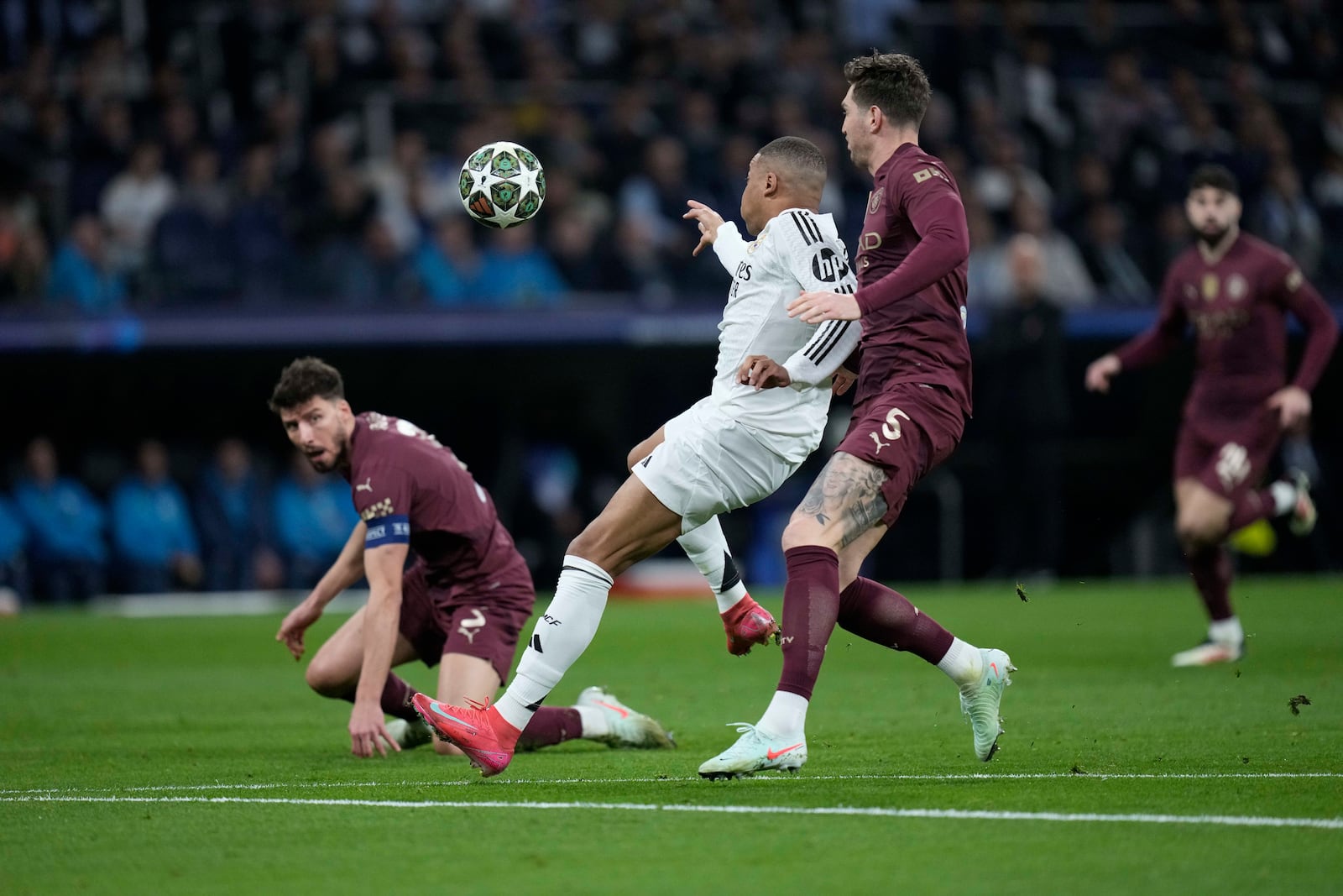 Real Madrid's Kylian Mbappe, center, scores the opening goal of his team during the Champions League playoff second leg soccer match between Real Madrid and Manchester City at the Santiago Bernabeu Stadium in Madrid, Spain, Wednesday, Feb. 19, 2025. (AP Photo/Bernat Armangue)