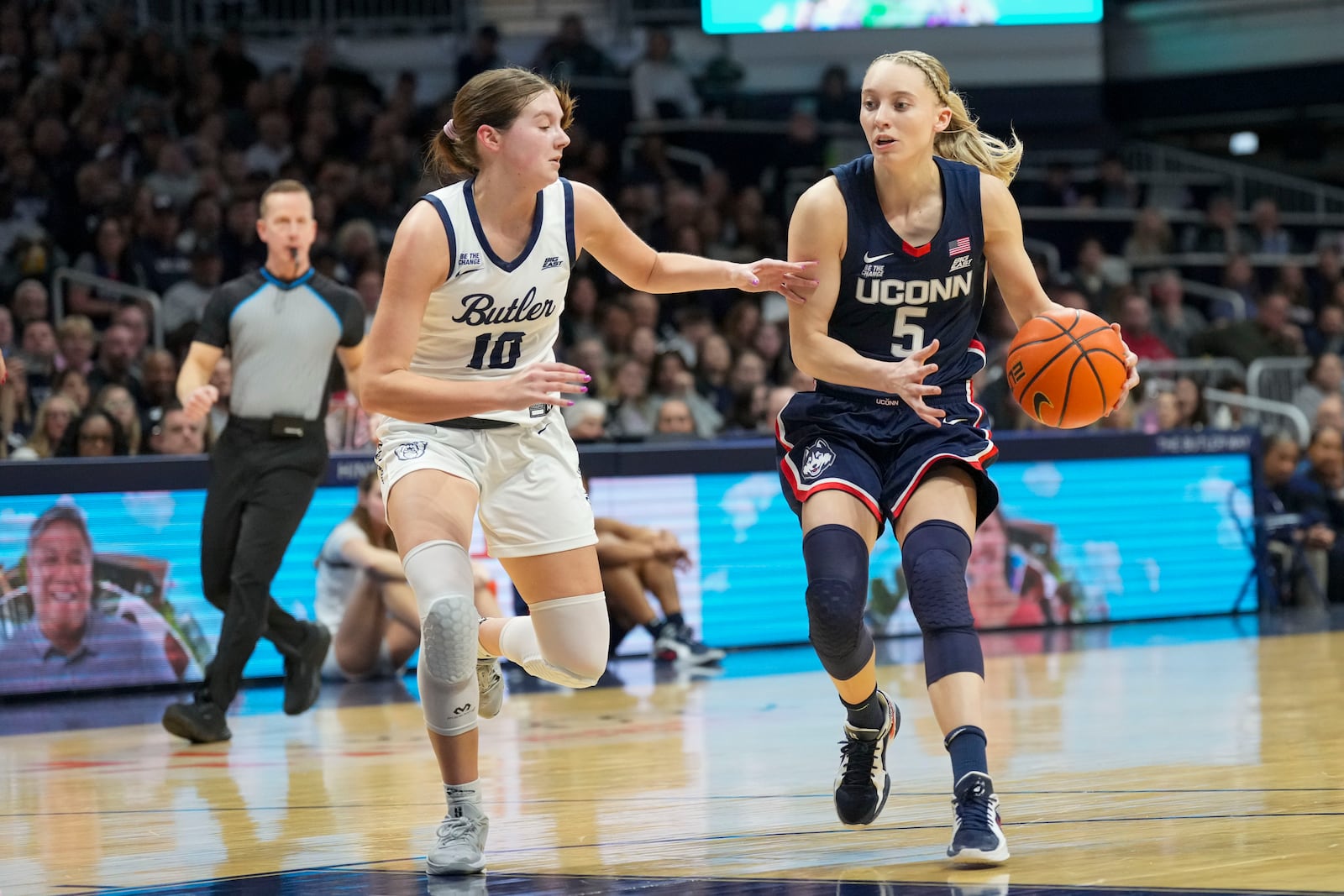 UConn guard Paige Bueckers (5) goes around Butler guard Lily Zeinstra (10) in the first half of an NCAA college basketball game in Indianapolis, Saturday, Feb. 22, 2025. (AP Photo/AJ Mast)