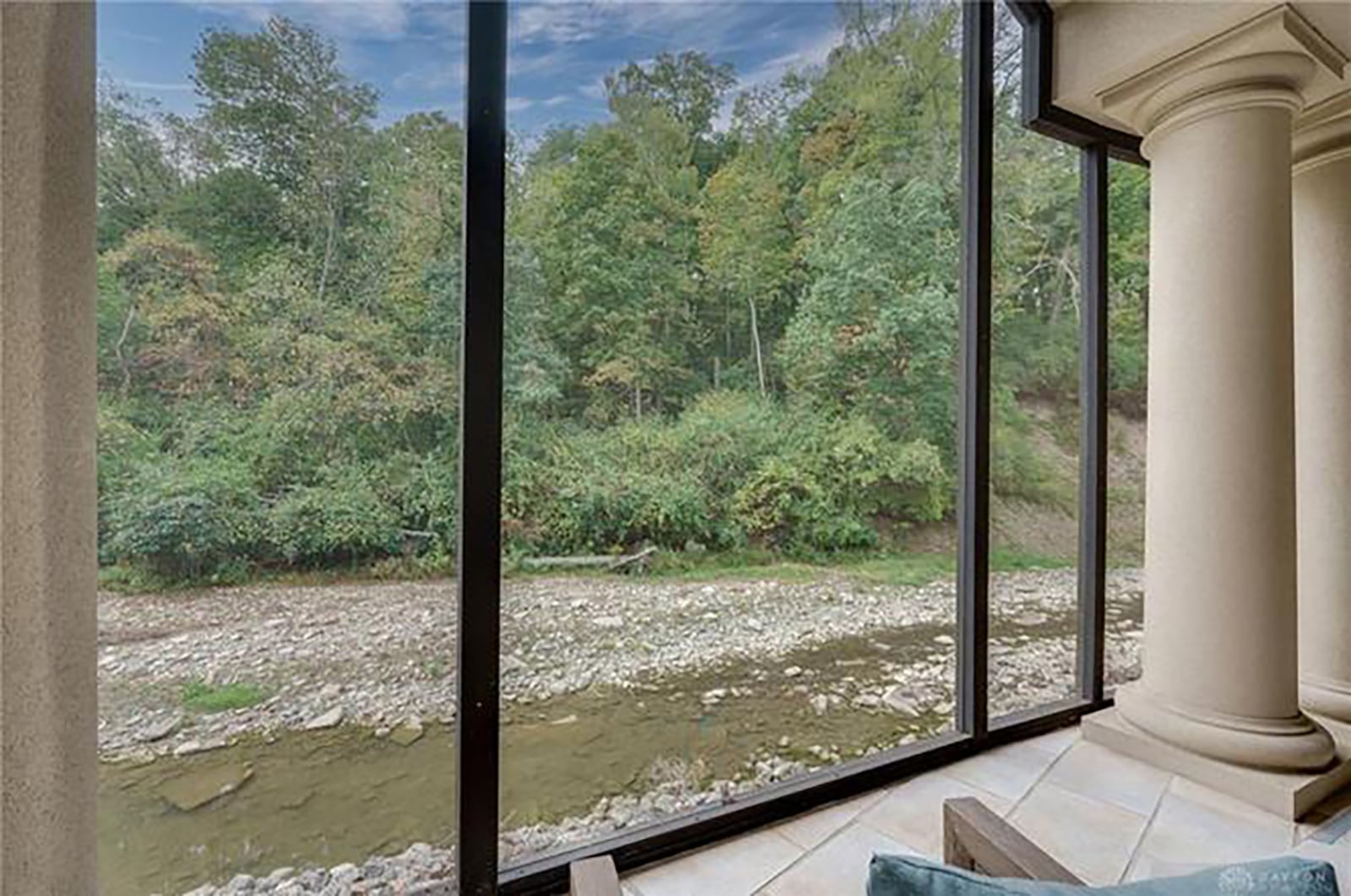 The home sits on Hole Creek and has views of the water from the many individual outdoor spaces, including this screened in porch.