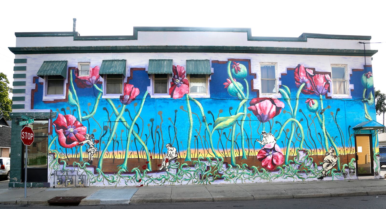 Poppies climb up the side of a building at 700 Xenia Ave. in Dayton. This mural was created by artists Tiffany Clark and Christopher "Etch" Weyrich, the original duo behind the Mural Machine. LISA POWELL / STAFF