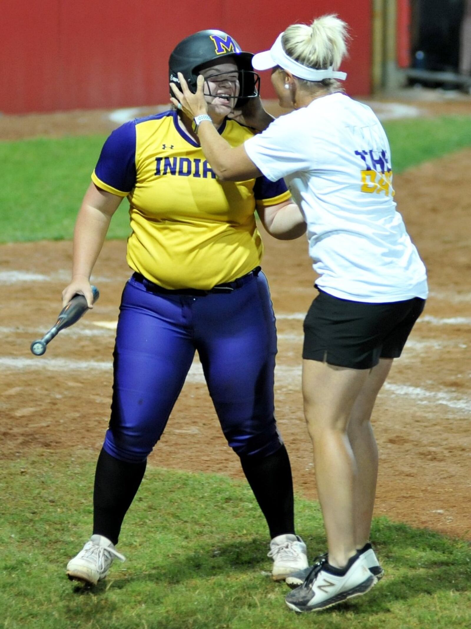 Mechanicsburg’s Hannah DeLong is greeted by her mother (and Indians coach) Abbey DeLong after hitting a two-run homer the seventh inning Friday night at Firestone Stadium in Akron. Mechanicsburg beat Jeromesville Hillsdale 7-3 in a Division IV state softball semifinal. RICK CASSANO/STAFF