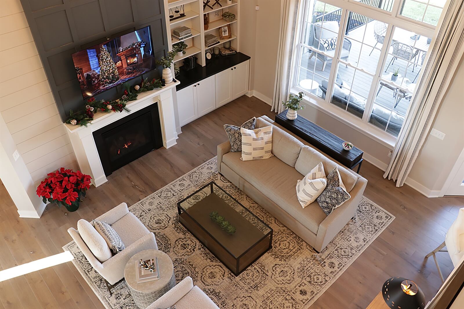 The centerpiece to the home is the two-story great room with a vaulted ceiling. A gas fireplace has a wood mantel and detail woodwork that extends the fireplace to the ceiling. A built-in bookcase with cabinetry is next to the fireplace and triple windows look out over the rear deck. CONTRIBUTED PHOTO BY KATHY TYLER