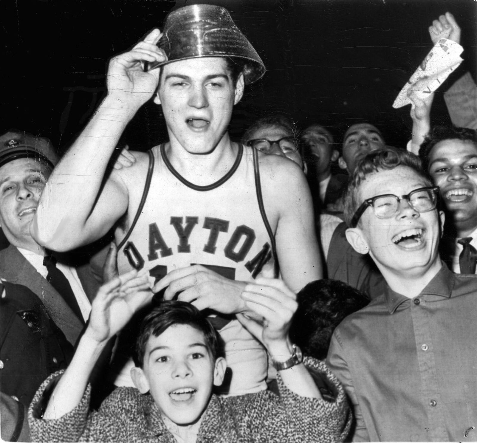 Bill Chmielewski, who led the University of Dayton to a 73-67 victory over St. John's in the finals of the National Invitation Basketball Tournament in 1962, is mobbed by delirious fans at the end of the game. On his head is the trophy he received as the most valuable player. UPI TELEPHOTO