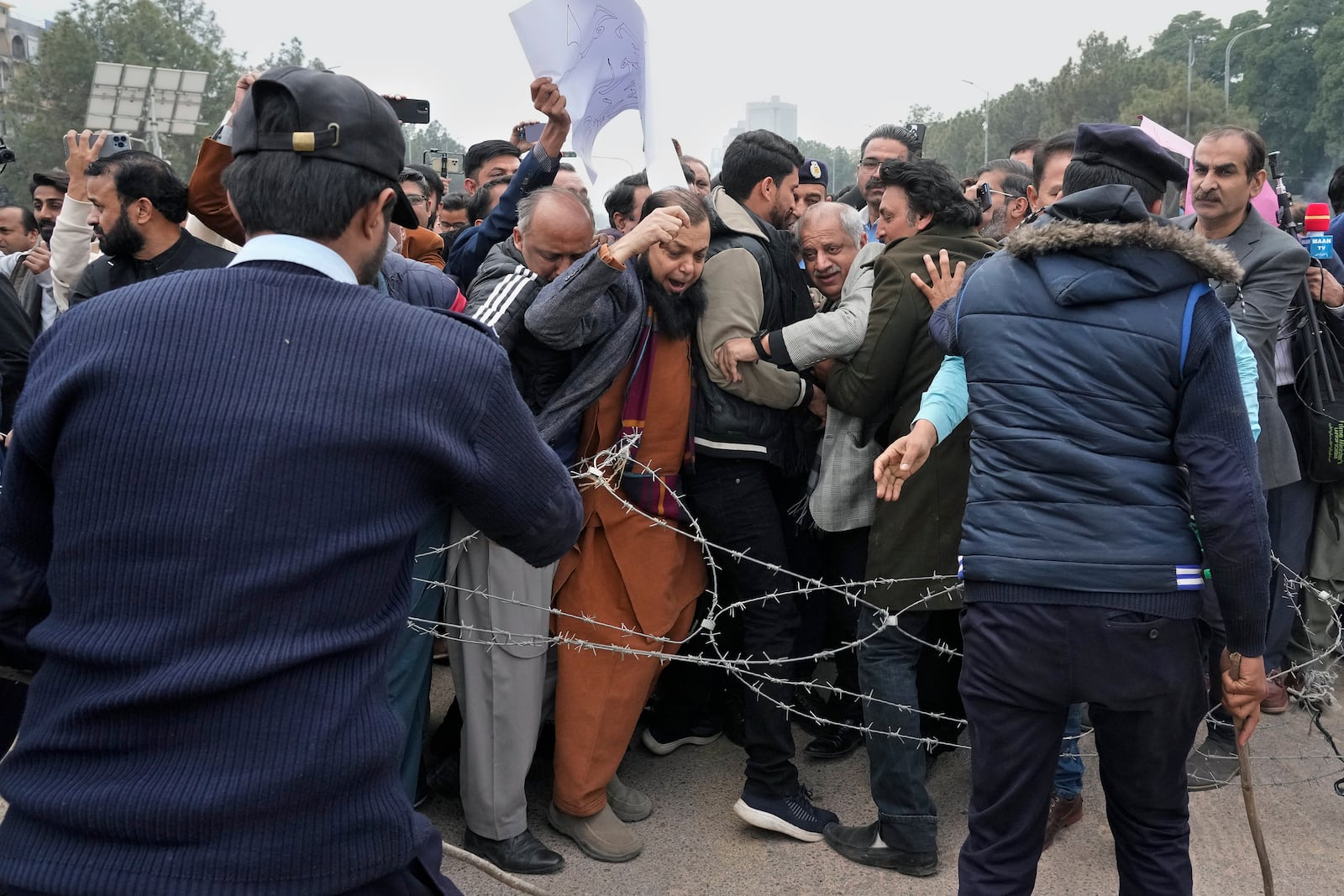 Police officer try to stop journalists marching toward parliament, in Islamabad, Pakistan, Tuesday, Jan. 28, 2025, during a rally to condemn a controversial 'Prevention of Electronic Crimes Act' bill passed by parliament that critics argue is designed to suppress freedom of speech. (AP Photo/Anjum Naveed)