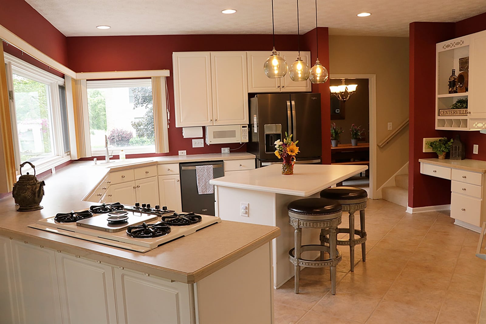 The heart of the house is the kitchen, which is nearly circular in design, allowing spoke-access to three rooms and the outdoor space. White cabinetry with beveled Corian countertops curves under a wall of windows, which provide panoramic views of the backyard oasis. CONTRIBUTED PHOTO BY KATHY TYLER