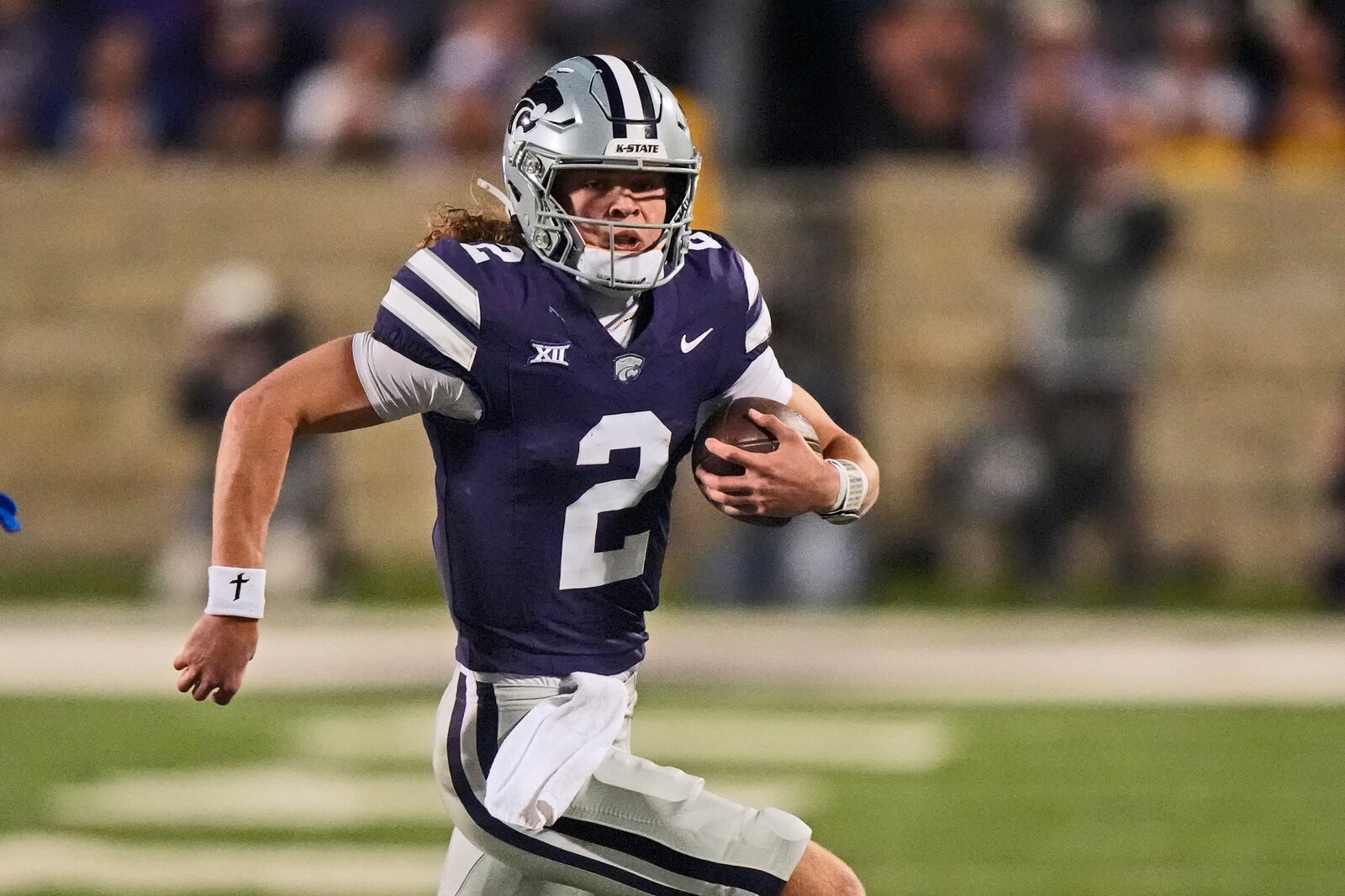 Kansas State quarterback Avery Johnson runs for a first down during the second half of an NCAA college football game against Kansas Saturday, Oct. 26, 2024, in Manhattan, Kan. (AP Photo/Charlie Riedel)