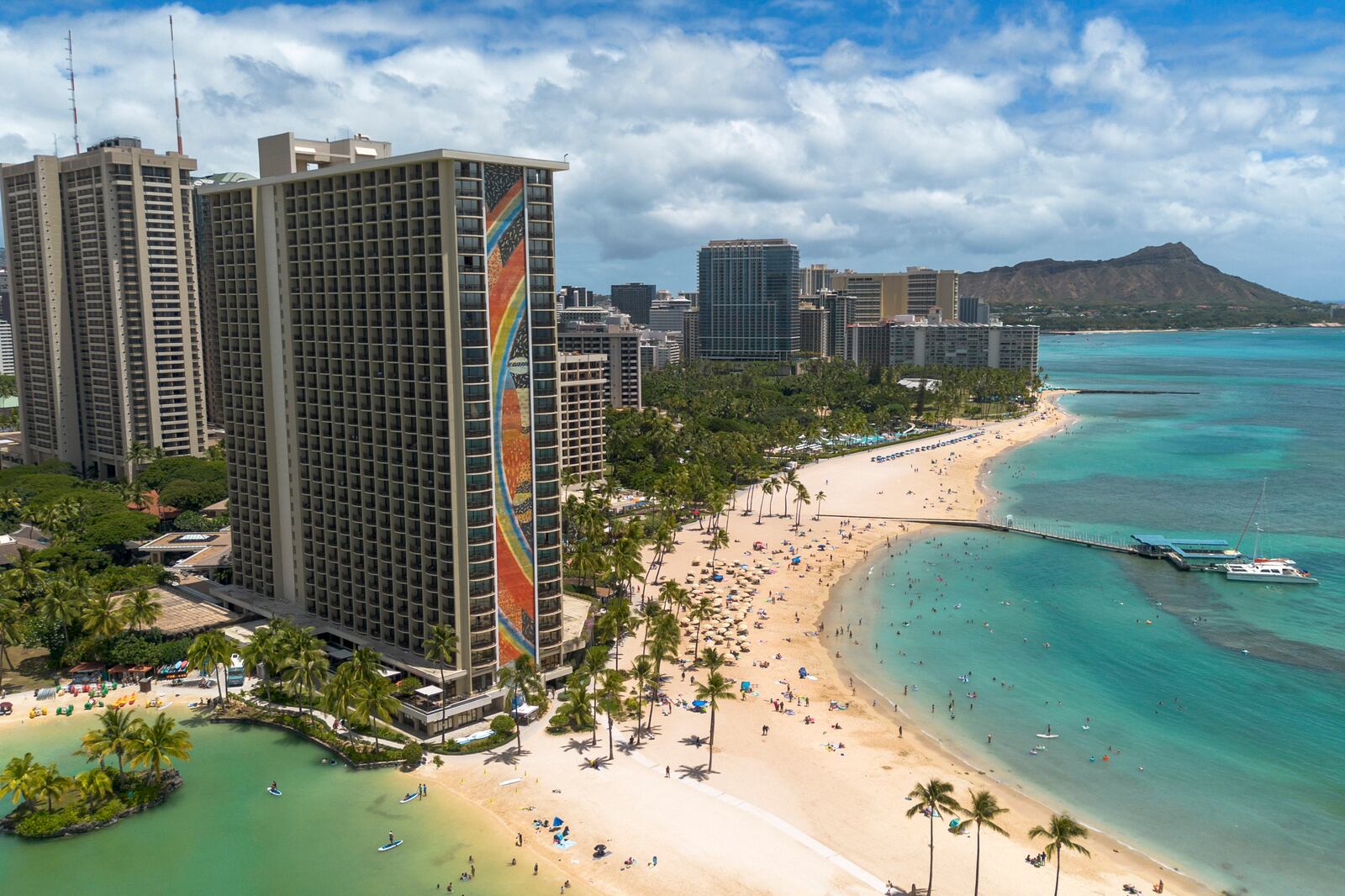 The Rainbow Tower of the Hilton Hawaiian Village Waikiki Beach Resort is seen on Thursday, Aug. 22, 2024, in Honolulu. The iconic 31-story Rainbow Mural was designed by artist Millard Sheets in 1968. (AP Photo/Mengshin Lin)