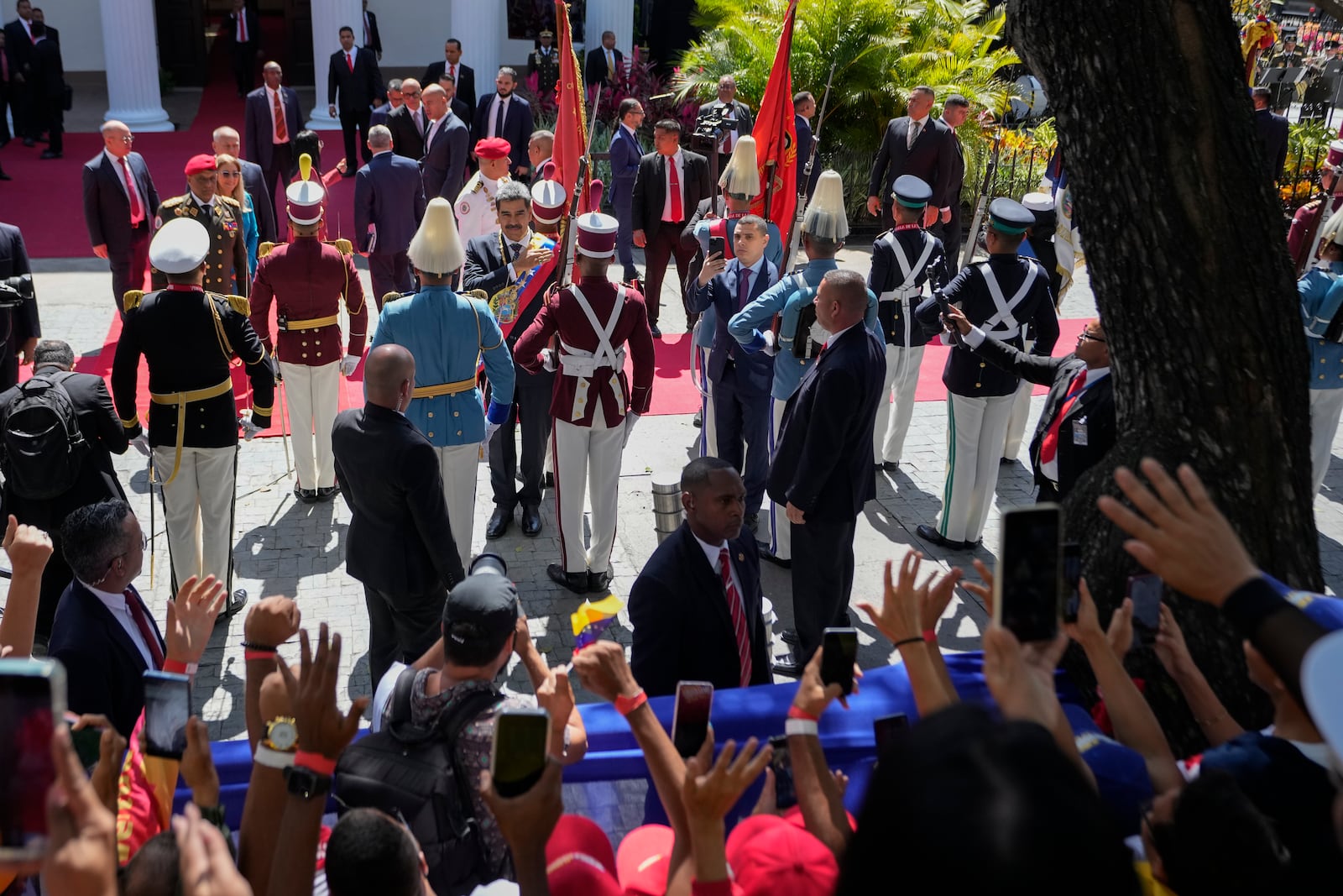 Venezuelan President Nicolas Maduro reviews the honor guard after being sworn in for a third term as government supporters gather outside the National Assembly in Caracas, Venezuela, Friday, Jan. 10, 2025. (AP Photo/Matias Delacroix)